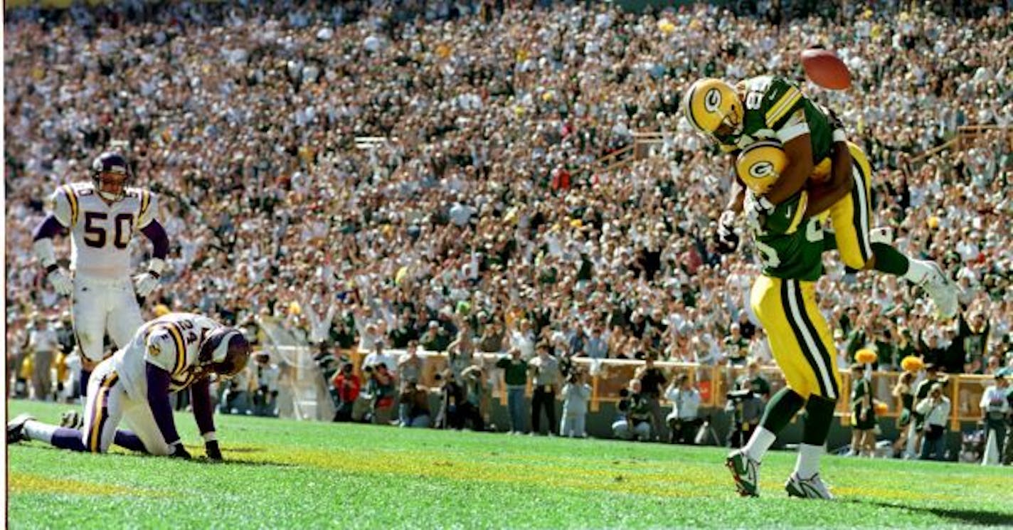 Green Bay�s #80 Derrick Mayes (top) celebrates with Terry Mickens after a Mickens TD in the 2nd Quarter. Vikings #50 Jeff Brady and Robert Griffith slump at left. The pack went up 28-7 on this play.