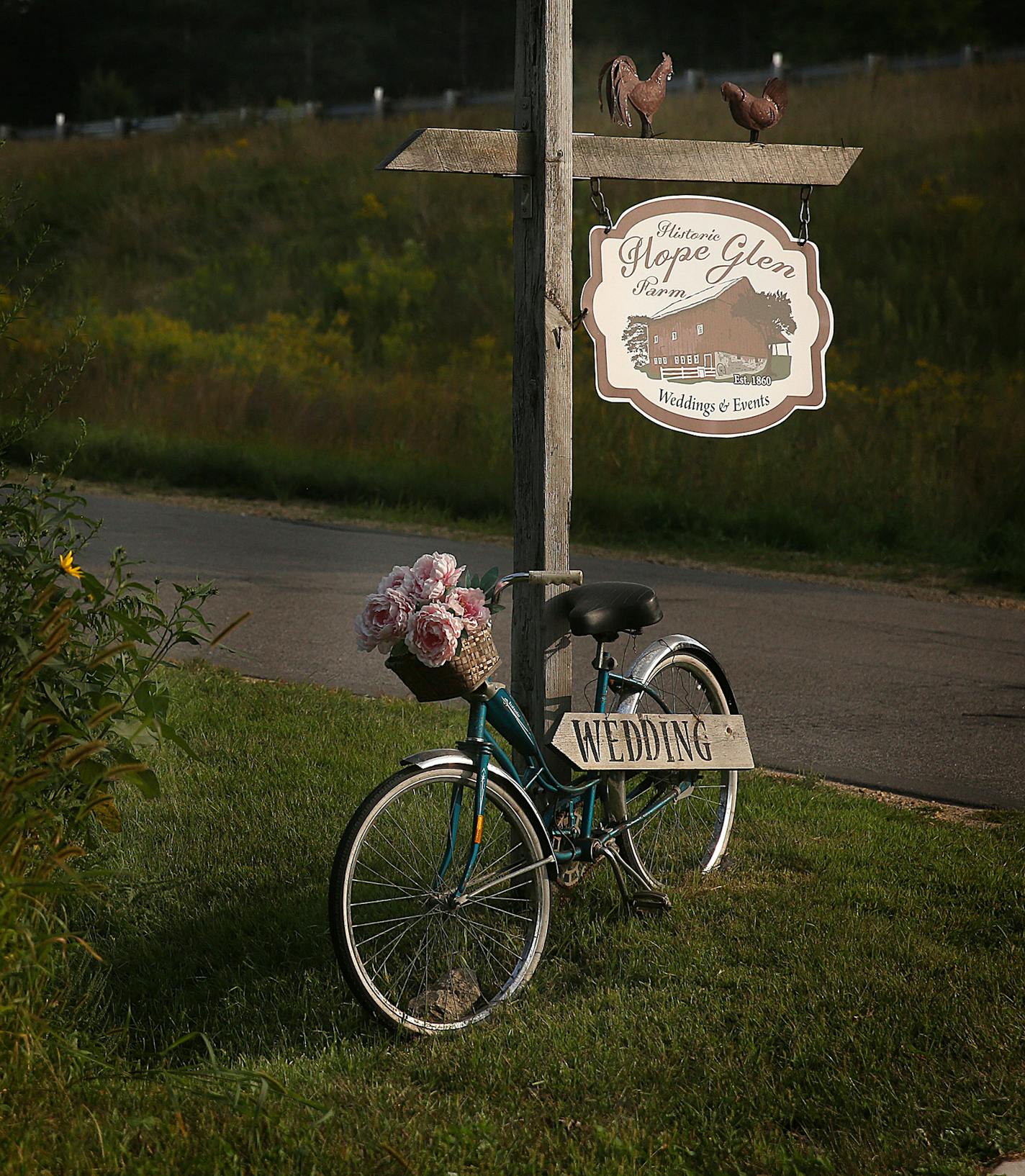 The entryway to Hope Glen Farm is uniquely marked. ] JIM GEHRZ &#xef; james.gehrz@startribune.com / Cottage Grove, MN / August 28, 2015 / 3:00 PM &#xf1; BACKGROUND INFORMATION: The sudden flourishing of wedding barns and other farmyard attractions, why the lure of such things just now, and the fightbacks that can happen with neighbors. A wedding is occurring at a wedding barn in Cottage Grove, Hope Glen Farm -- bride Savannah puts on wedding dress 2:20 pm / then bridal photos at 3:20 family at 3