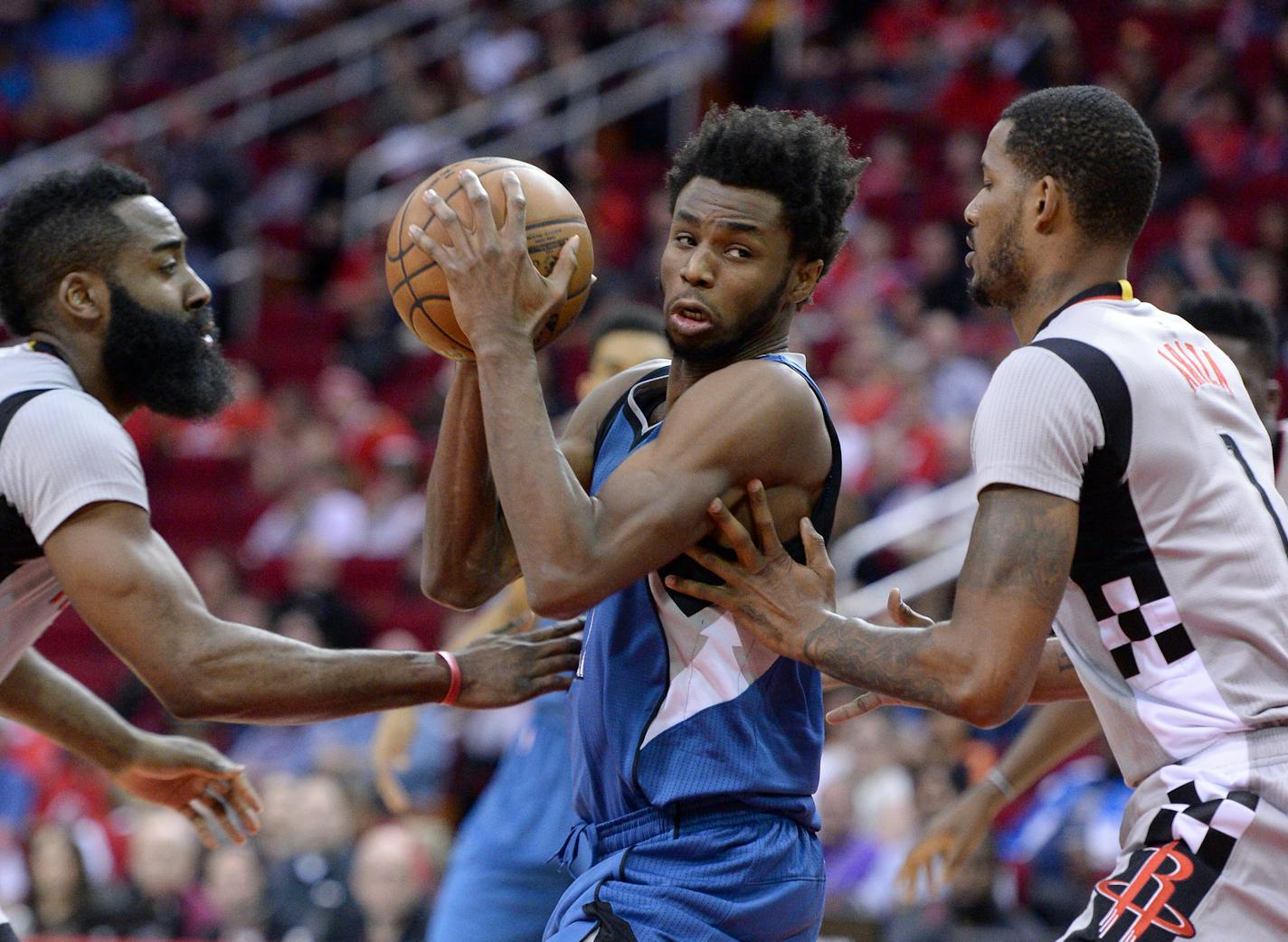 Minnesota Timberwolves forward Andrew Wiggins (22) drives between Houston Rockets guard James Harden, left, and Trevor Ariza in the first half of an NBA basketball game Saturday, Feb. 25, 2017, in Houston. (AP Photo/George Bridges)