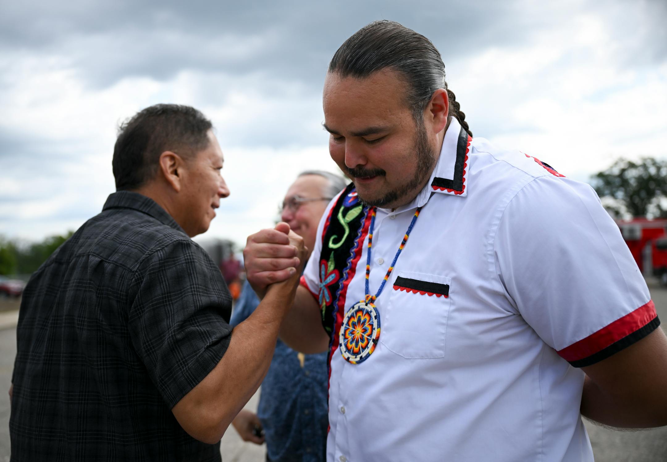 Red Lake Nation Tribal Secretary Samuel Strong shares and embrace with tribal council member Eugene Standing Cloud, left, after the opening of the state's first recreational marijuana dispensary Tuesday, Aug. 1, 2023 outside NativeCare in Red Lake, Minn.