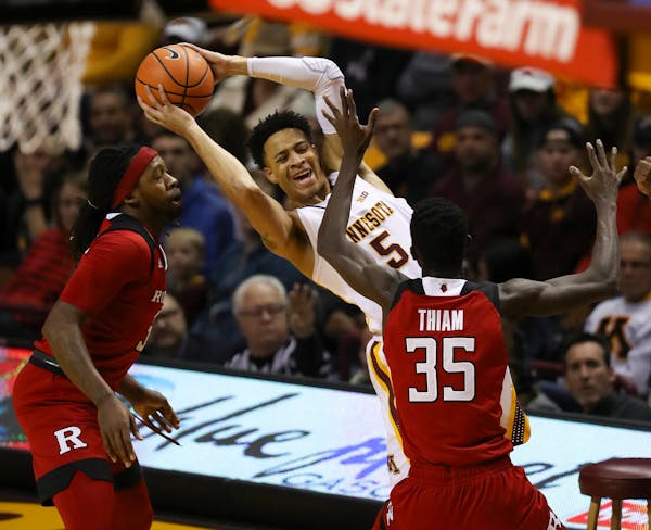Minnesota Gophers guard Amir Coffey (5) was smothered by the defense of Rutgers guard Issa Thiam (35) and forward Deshawn Freeman (33) in the first ha