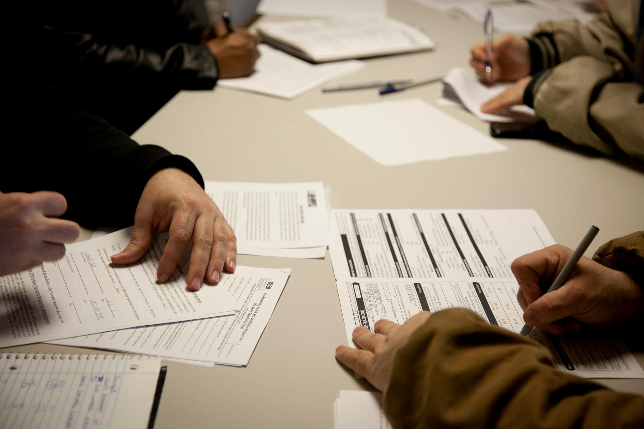 People fill out applications for temporary or temp-to-hire positions during a job fair at Award Staffing in Bloomington, Minnesota, U.S., on Wednesday, Dec. 21, 2011. Payrolls increased in 29 states in November, while the jobless rate declined in 43, a sign the labor market is recovering across much of the U.S. Photographer: Ariana Lindquist/Bloomberg