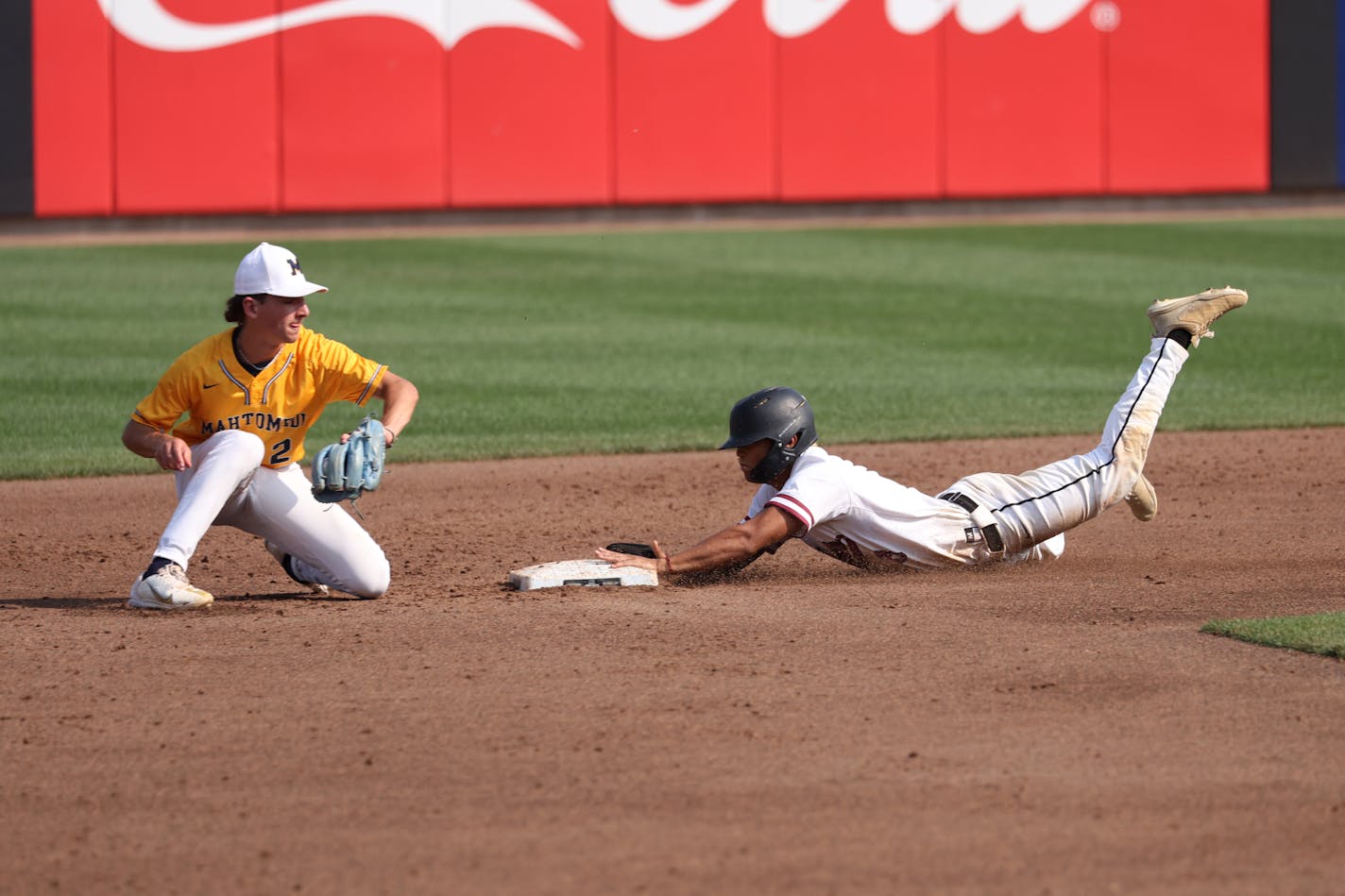 New Prague's Aiden Jackson dives into second base ahead of the throw to Mahtomedi second baseman Charlie Barre.