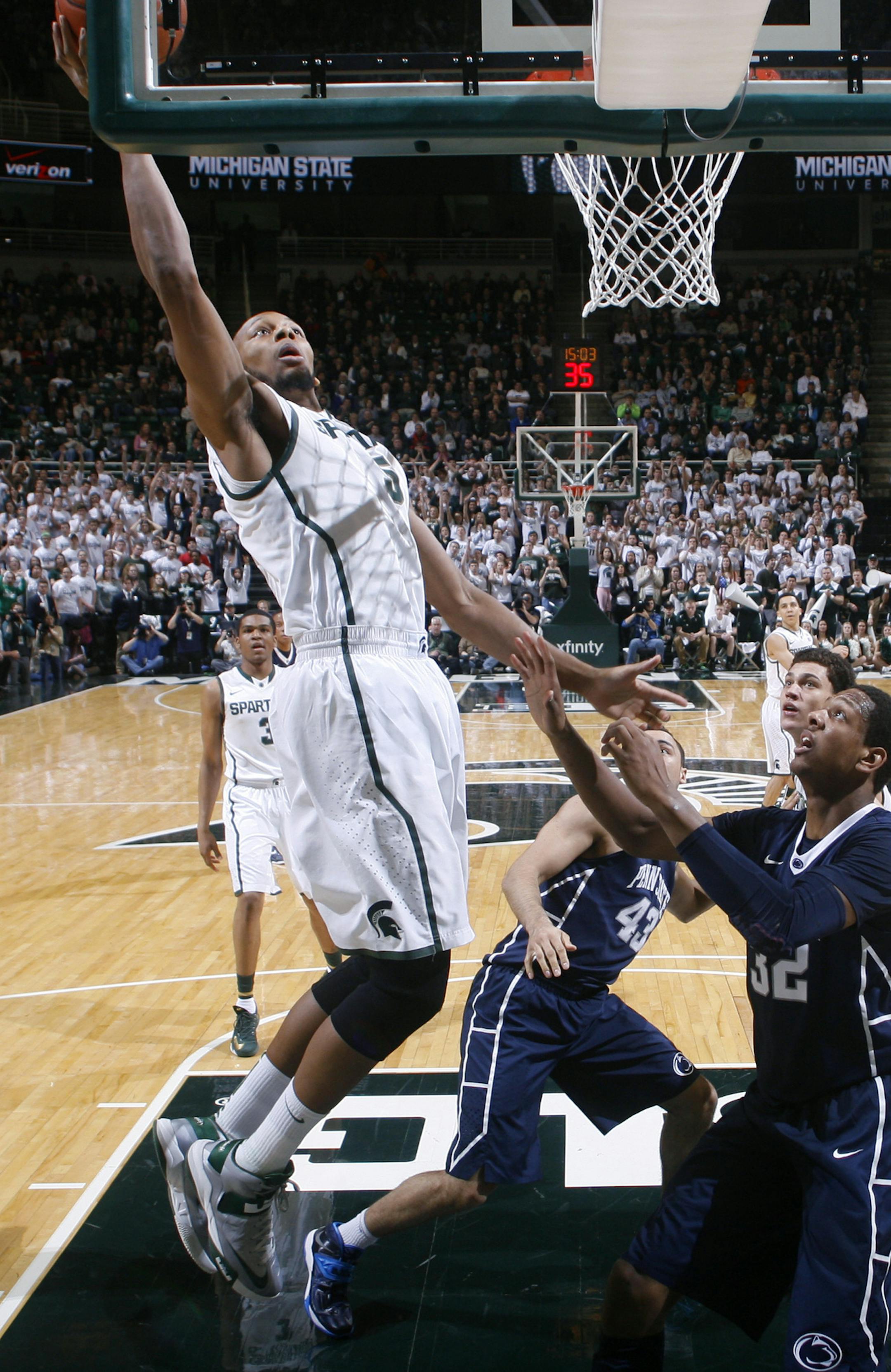 Michigan State's Adreian Payne, left, shoots over Penn State's Jordan Dickerson (32) and Ross Travis (43) during the first half of an NCAA college basketball game on Thursday, Feb. 6, 2014, in East Lansing, Mich. (AP Photo/Al Goldis)