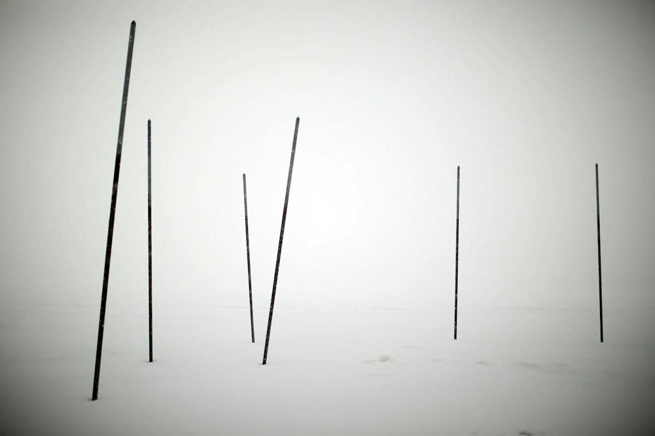 Feb. 20, 2014: What forecasters say might be the largest snowfall of the winter began falling Thursday afternoon in Minneapolis. Poles in the ice of Lake Harriet as snow obscured the rest of the landscape.