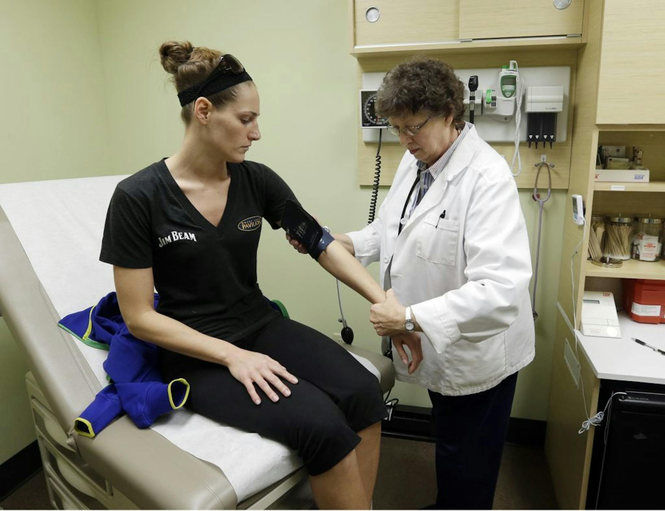 FILE - In this April 3, 2013 file photo, family nurse practitioner Ruth Wiley examines Elizabeth Knowles at a Walgreens Take Care Clinicin Indianapolis. The once-simple relationship between patients and the family doctor is fast becoming a throwback to another era as new alternatives emerge and primary care becomes more like a commodity, with access to doctors increasingly based on what consumers will pay.