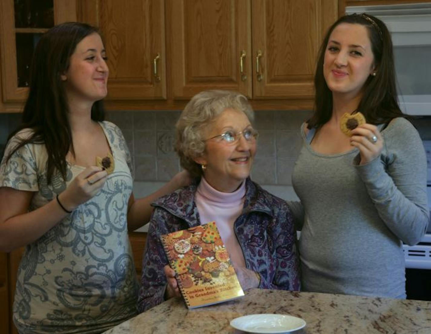 Millie Rice, seated, made a book of recipes she developed with each of her grandchildren, including twins Maggie, left, and Bridget Hooley.