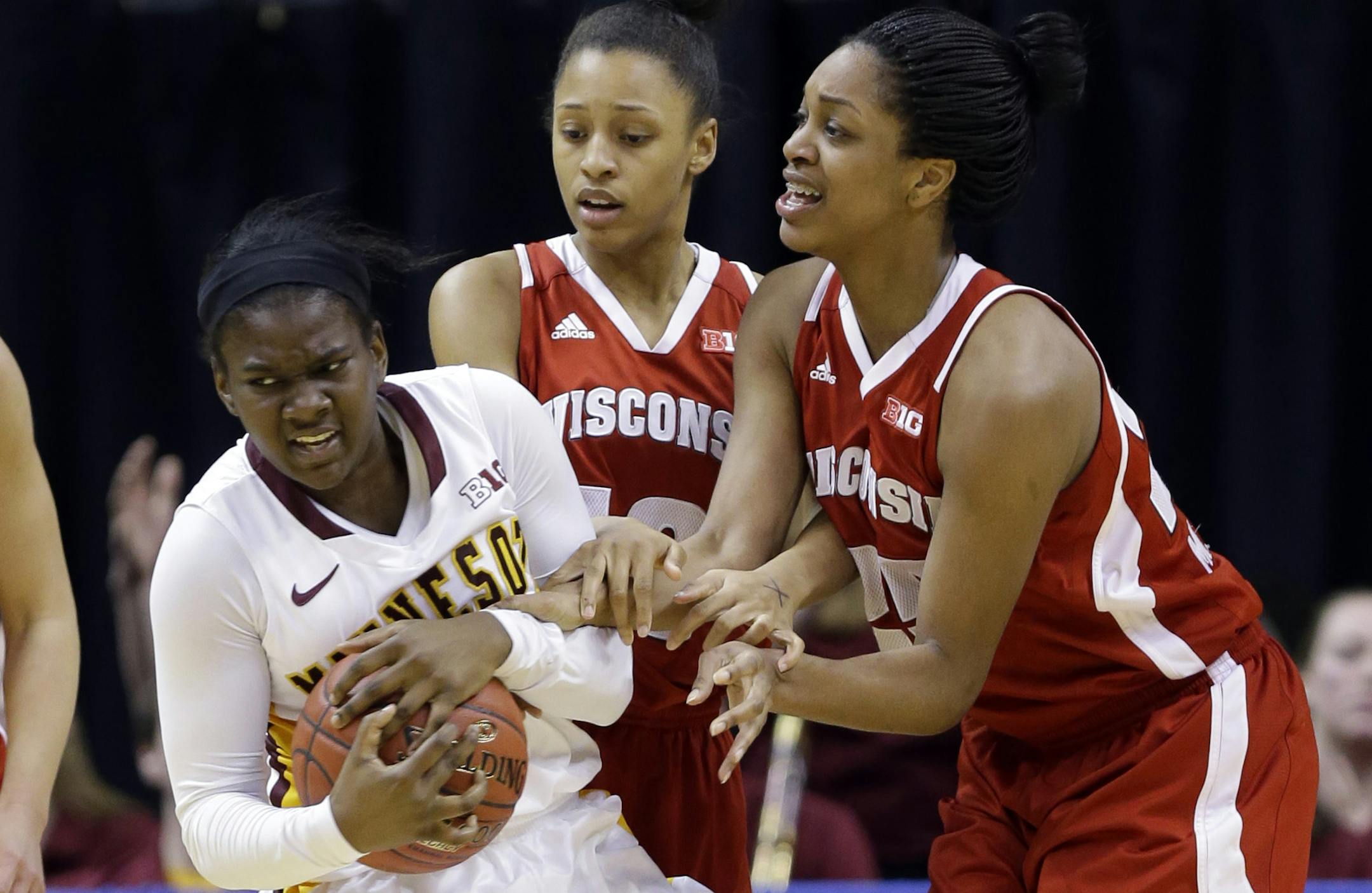 Minnesota's Stabresa McDaniel, left, fights for the ball with Wisconsin's Dakota Whyte, center, and Michala Johnson.