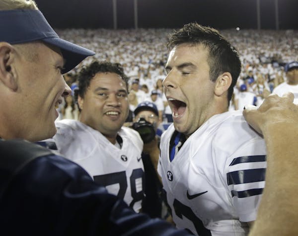 BYU quarterback Tanner Mangum, right, celebrates on the sidelines in the second half during an NCAA college football game against Boise State Saturday