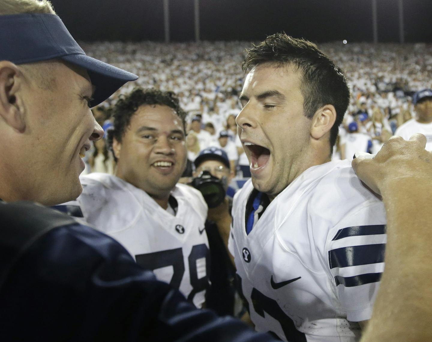 BYU quarterback Tanner Mangum, right, celebrates on the sidelines in the second half during an NCAA college football game against Boise State Saturday, Sept. 12, 2015, in Provo, Utah. BYU won 35-24.(AP Photo/Rick Bowmer)