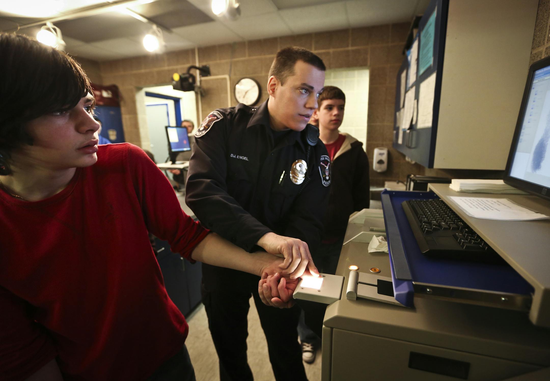 Officer David Engel fingerprinted Matt Morgan, 14, during a Teen Police Academy tour of where people are booked at the Apple Valley Police Department on Tuesday, March 19, 2013, in Apple Valley, Minn. The Apple Valley Police Department holds a Teen Police Academy each Jan. through March for about 20 teens who are interested in law enforcement. ] (RENEE JONES SCHNEIDER * reneejones@startribune.com) Jon epperson CQ