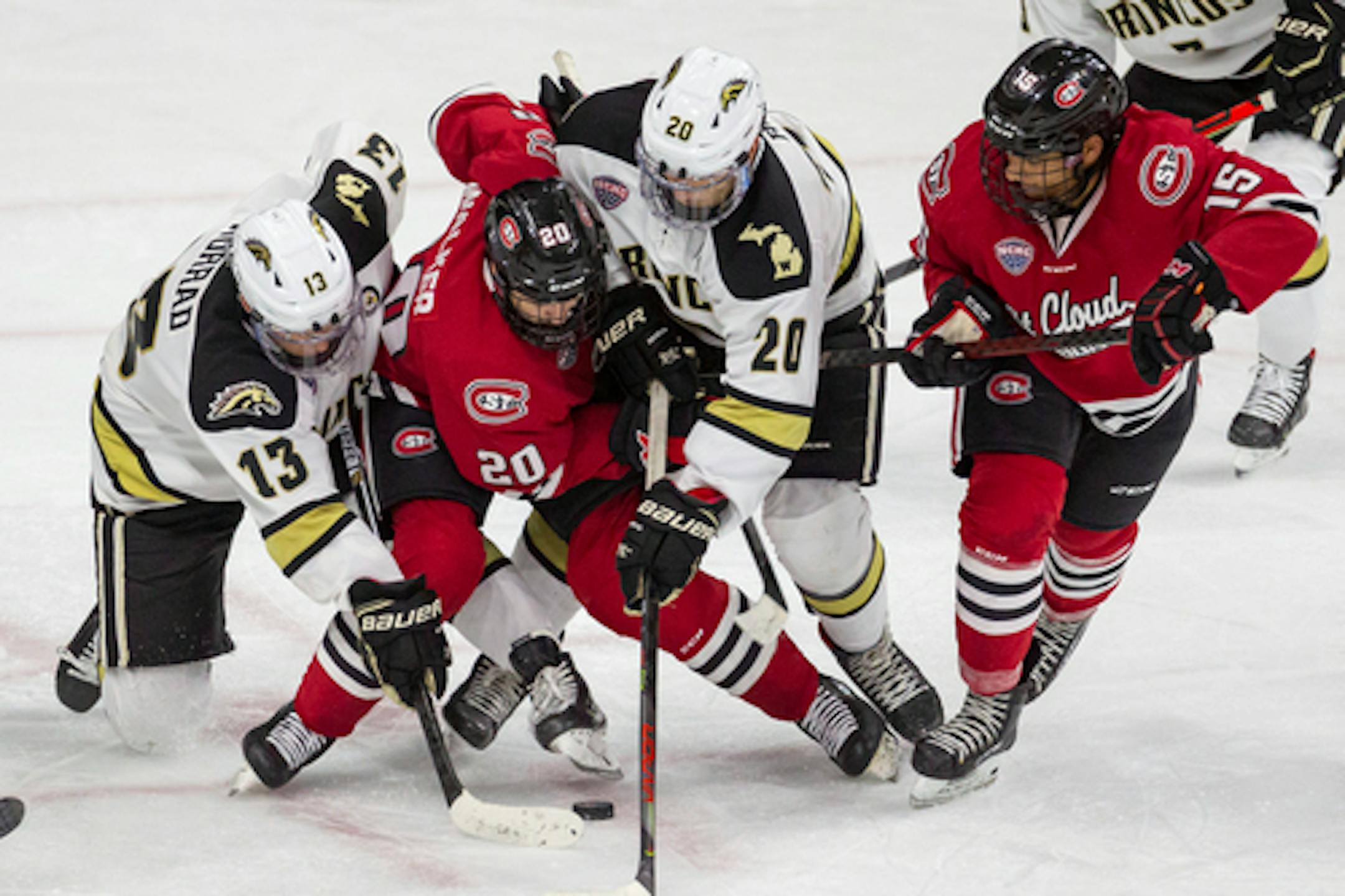 Western Michigan forward Drew Worrad (13), St. Cloud State forward Nolan Walker (20), Western Michigan forward Jamie Rome (20), and St. Cloud State forward Micah Miller (15) all fighting for the puck during an NCAA hockey game on Tuesday, Dec. 1, 2020, in Omaha, Neb. (AP Photo/John Peterson)