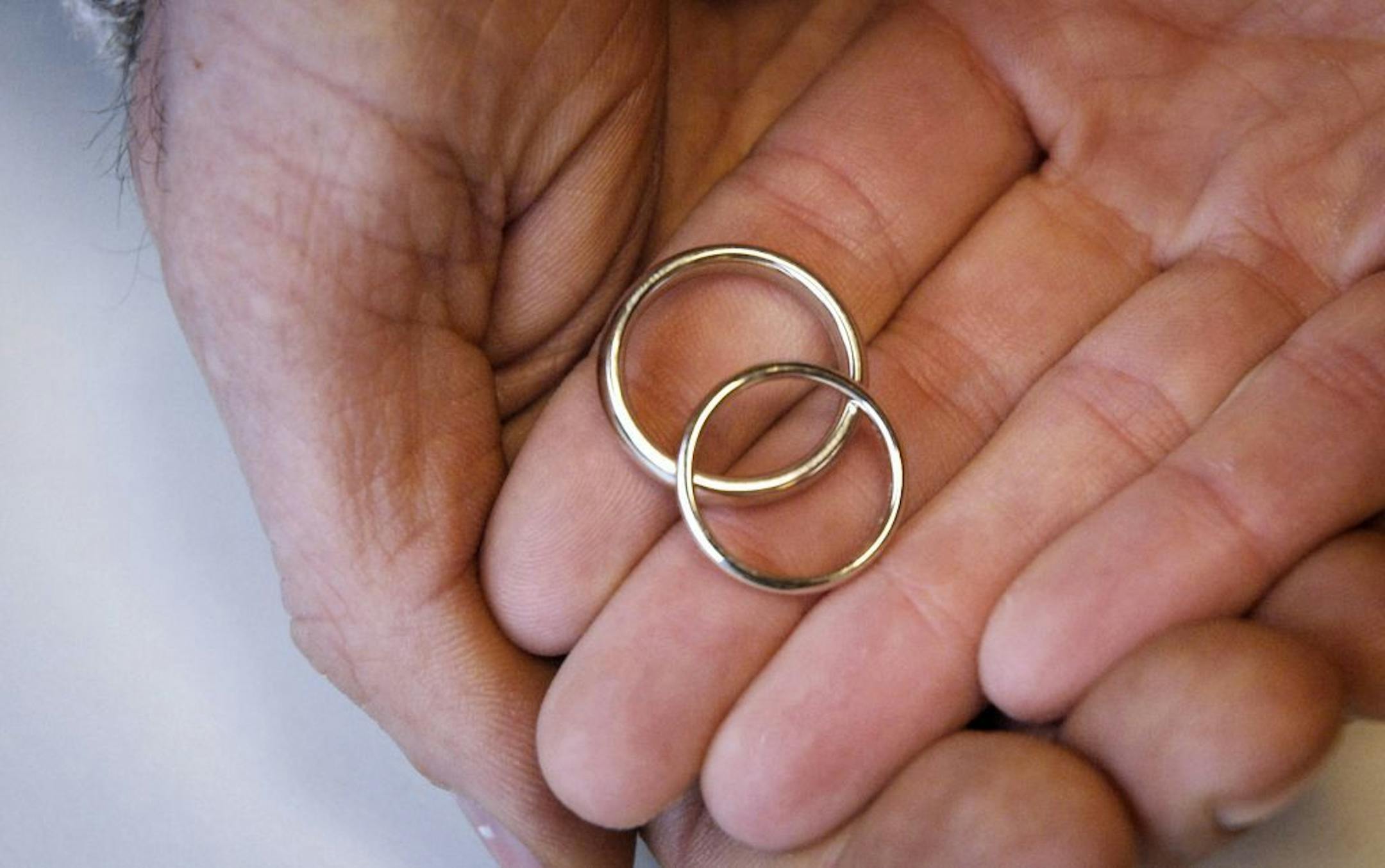 GLEN STUBBE � gstubbe@startribune.com Thursday, March 15, 2007 -- Minneapolis, Minn. -- Joshua Houdek and Kristi Papenfuss hold their wedding bands, made of recycled white gold. // rings, green weddings //