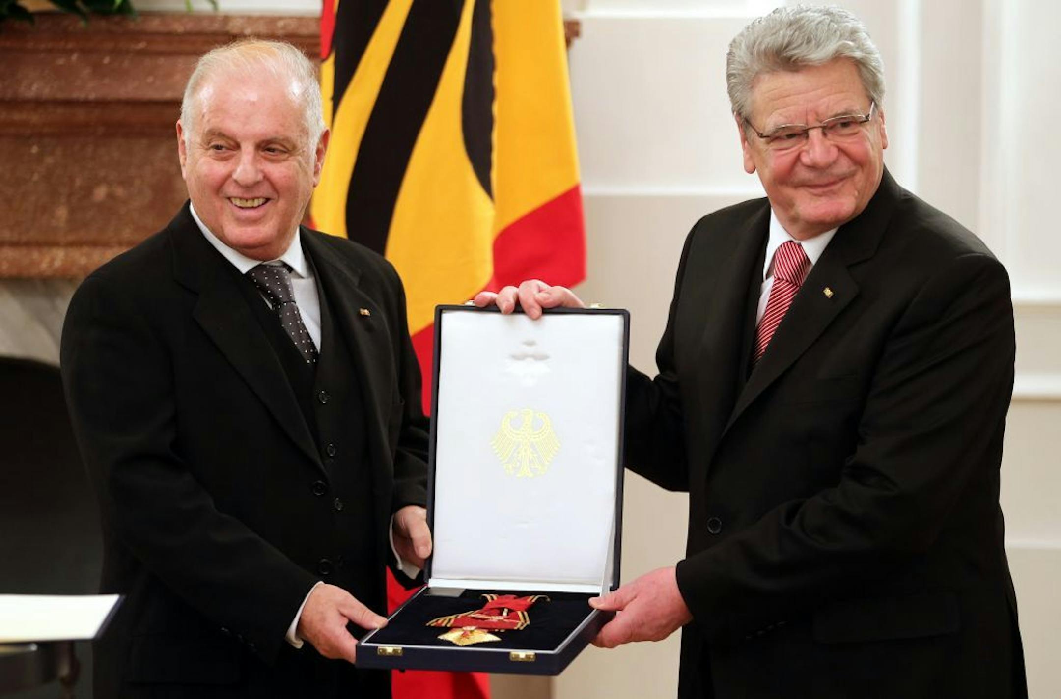 In this photo made available Wednesday, Feb. 6, 2013, German President Joachim Gauck, right, presents the Order of Merit of the Federal Republic of Germany Music Director of the Berlin State Opera Daniel Barenboim, left, at Bellevue Palace in Berlin, Germany. The Argentine-Israeli conductor and pianist was awarded the Grand Merit Cross with Star and Sash on the occasion of his 70th Birthday. (AP Photo/dpa, Wolfgang Kumm) ORG XMIT: MIN2013030809381211
