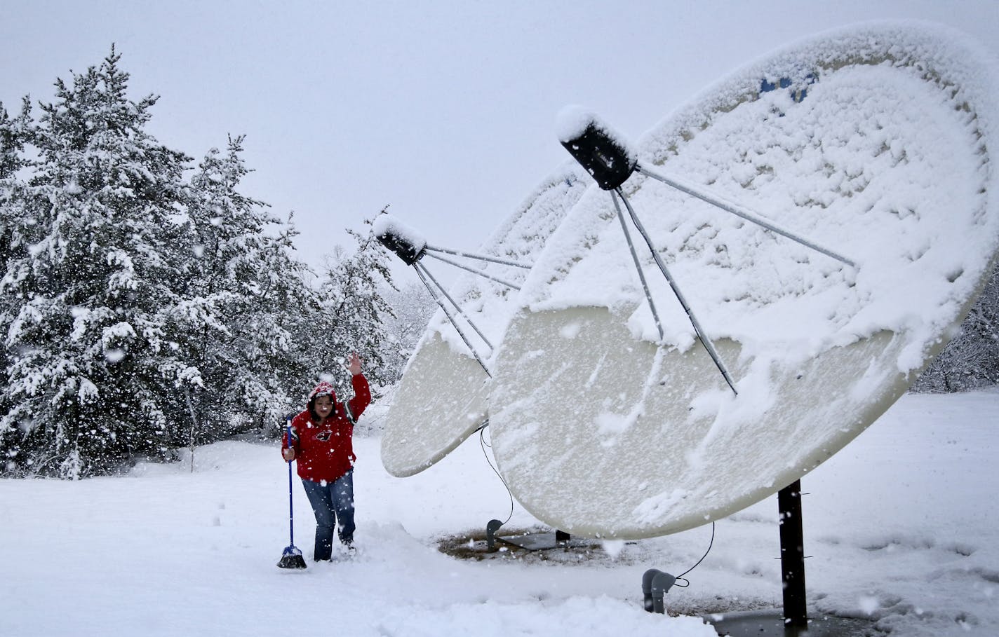 KOJB morning DJ Marie Rock trudges through deep snow after attempting to clear the station's satellite dishes of several inches of freshly fallen snow Friday, March 21, 2014, in Cass Lake, MN. Also known at The Eagle, broadcasting at 90.1 FM, KOJB is the official radio station of the Leech Lake Reservation.(DAVID JOLES/STARTRIBUNE) djoles@startribune.com While most of the state takes cell phone service and broadband computer access increasingly for granted, northern Minnesota Indian Reservations