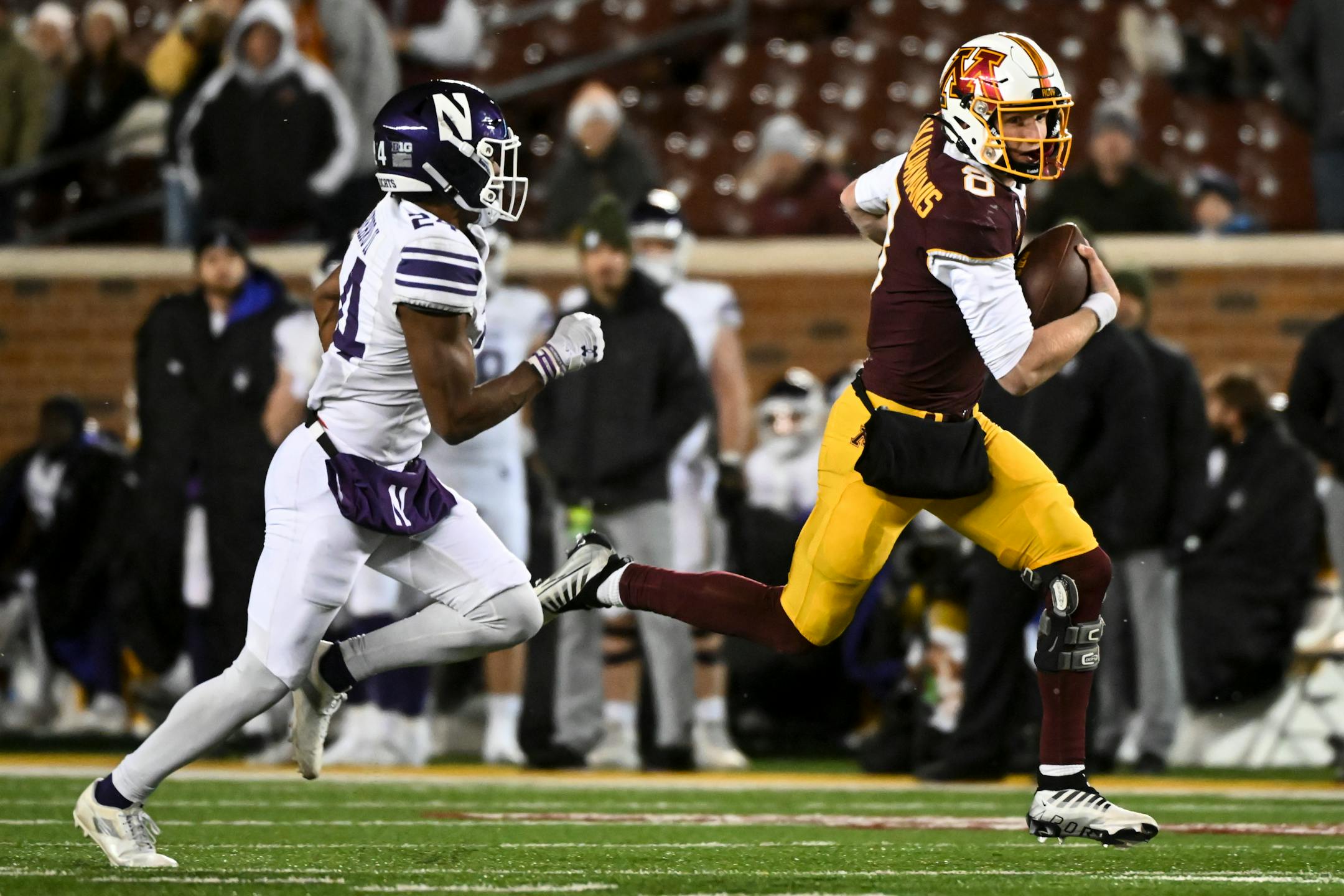 Minnesota Gophers quarterback Athan Kaliakmanis (8) ran for a first down with Northwestern Wildcats defensive back Rod Heard II (24) in pursuit during the second half.