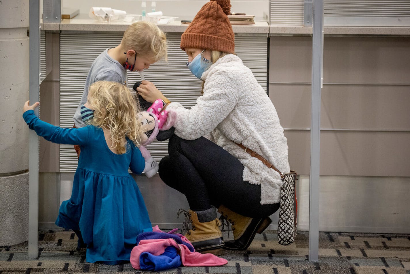 Brittany Johnson retrieved saliva from her 4-year-old twins Josephine and Everett as they made their way through the new saliva COVID-19 testing site at the Minneapolis-St. Paul International Airport, Thursday, Nov. 12, 2020.