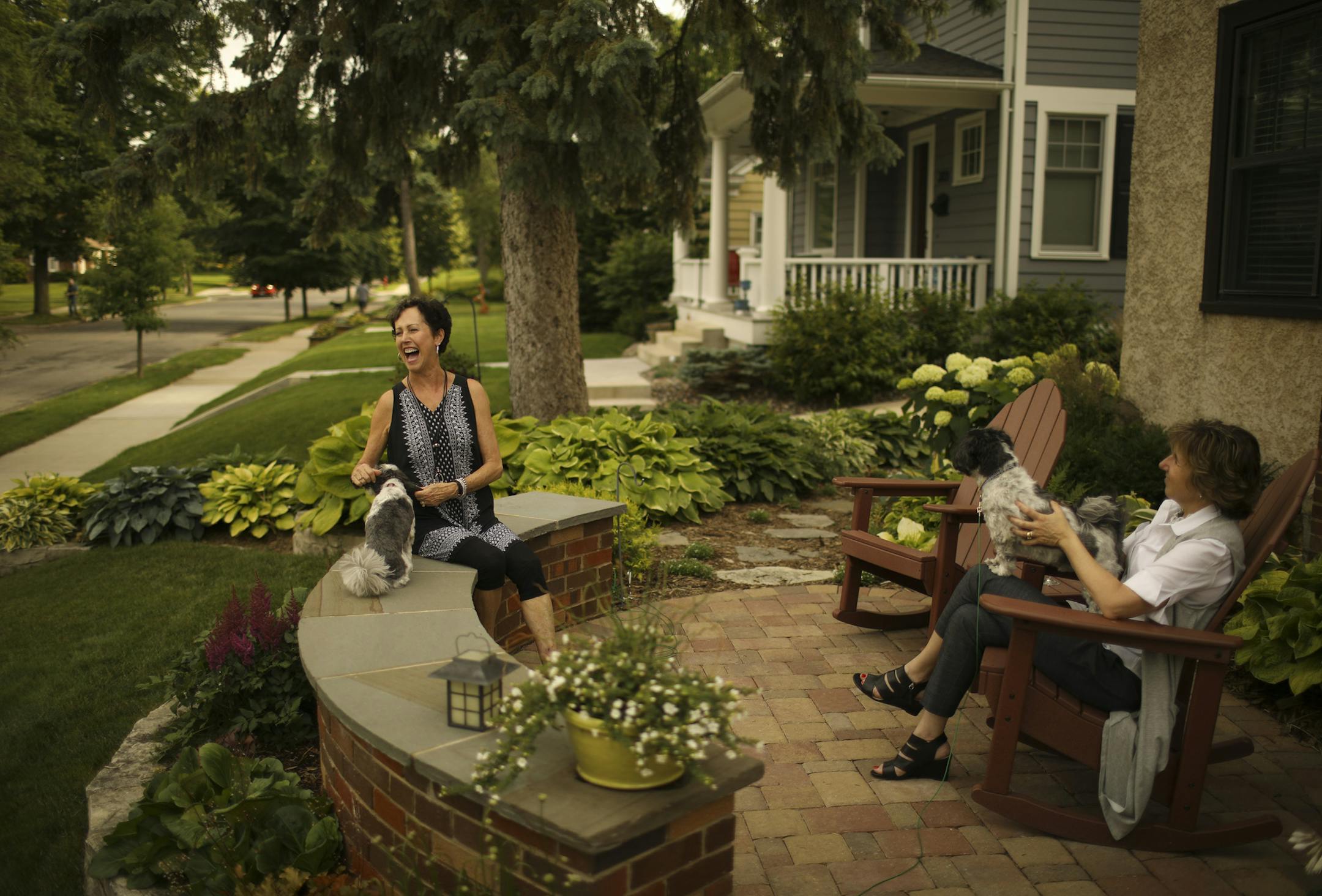 Bobbi Deeney, left, and Beth Gunderson with their dogs, Oliver and Nelson, on the patio in front of Deeney&#x2019;s house.