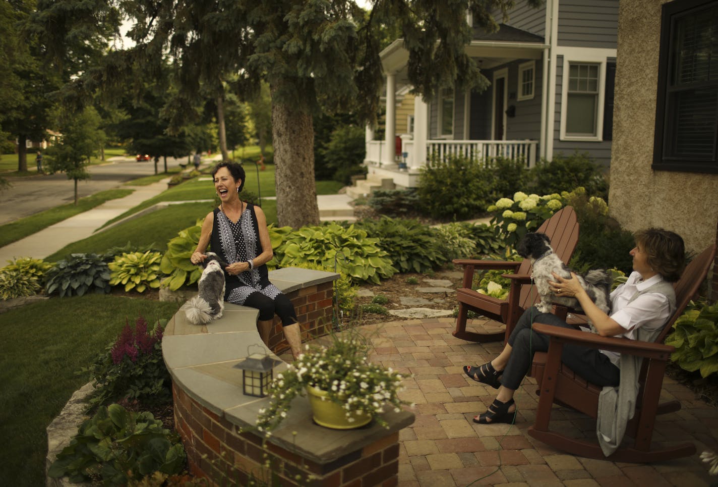 Bobbi Deeney, left, and Beth Gunderson with their dogs, Oliver and Nelson, on the patio in front of Deeney&#x2019;s house.