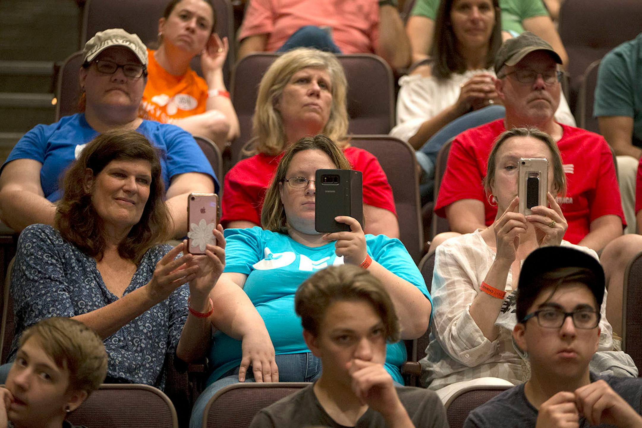 Audience members record the student panel on their cell phones.