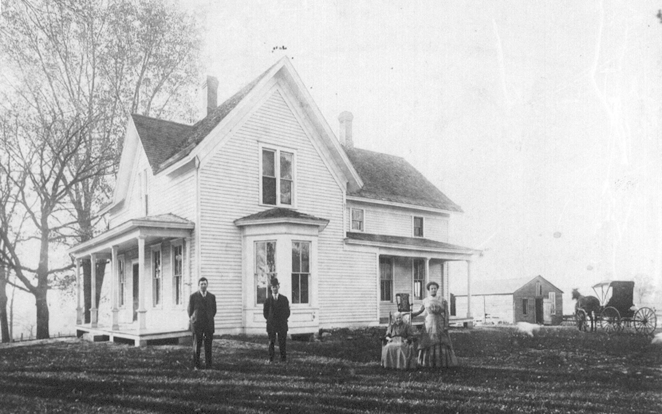 Rev. Boutwell's daughter Kate is shown in the rocking chair in the front yard in about 1910.
