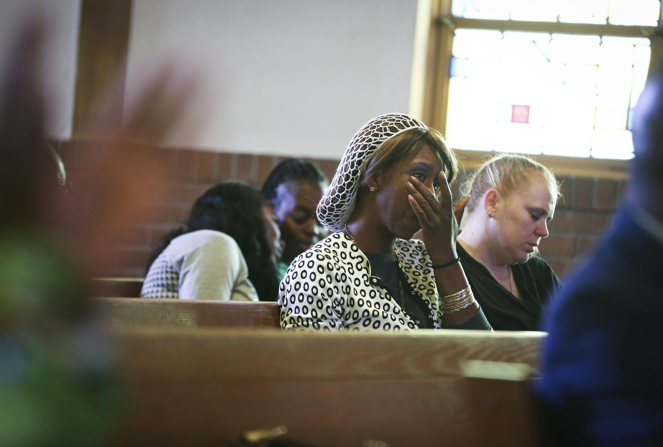 Kellita Whisnant wiped away tears during a prayer service in Robbinsdale on Sunday. The Ebola outbreak feels close for many Minnesota families.