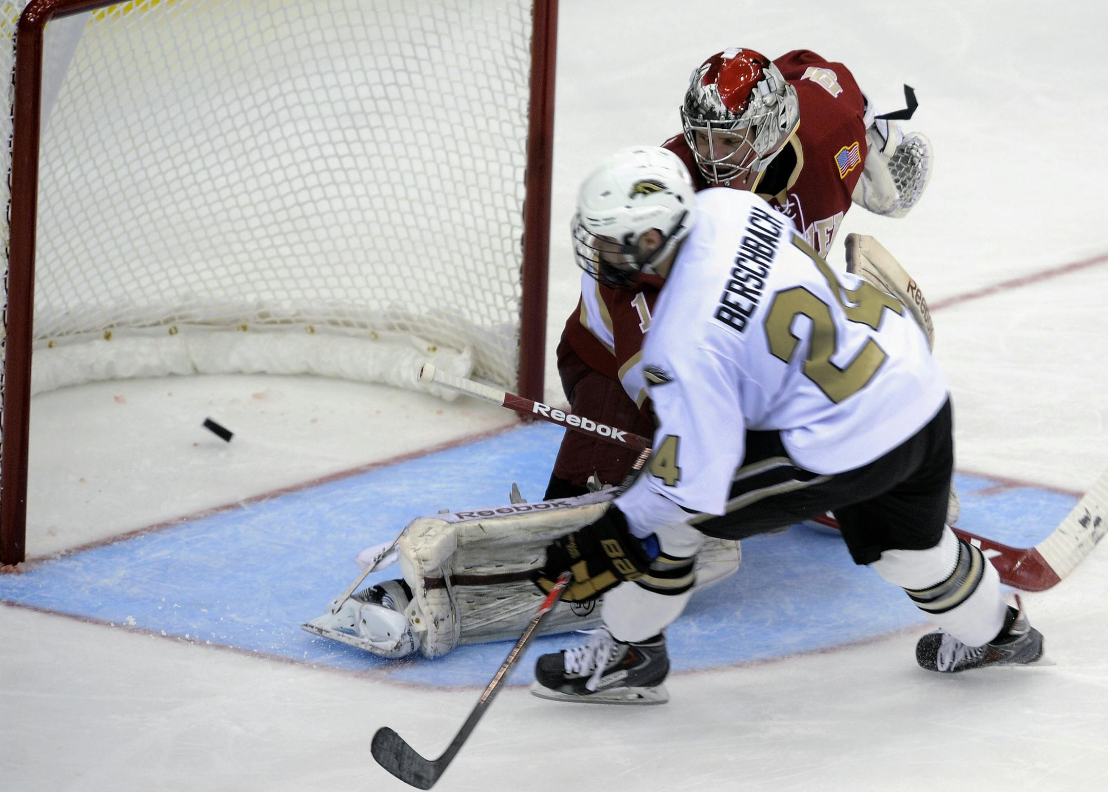 Western Michigan's Shane Berschbach (24) puts the puck past Denver goalie Sam Brittain, left, for a breakaway goal during the second period in an NCAA hockey game in the semifinals of the National Collegiate Hockey Conference tournament in Minneapolis, Friday, March 21, 2014. (AP Photo/Tom Olmscheid)