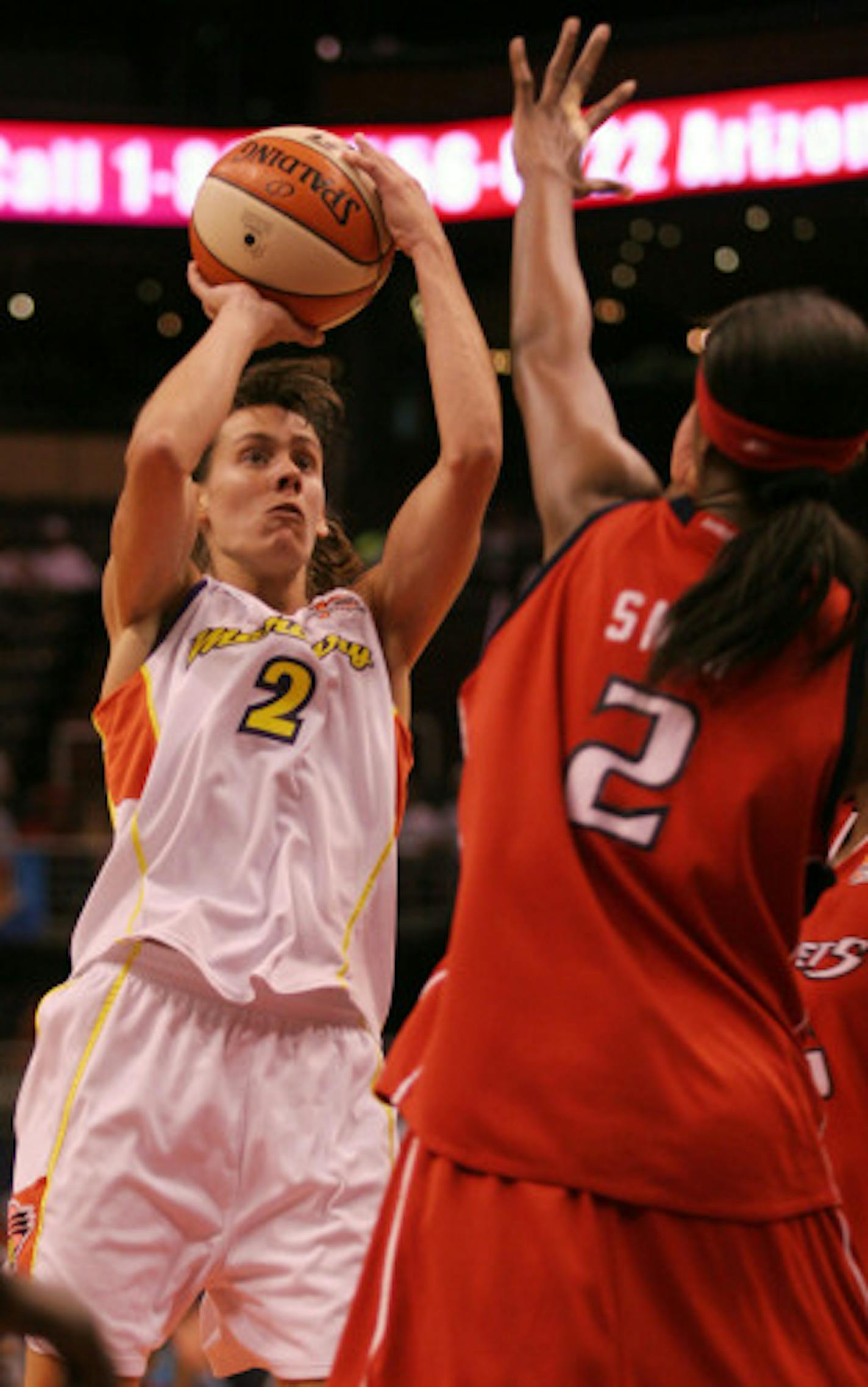 Phoenix Mercury guard Kelly Miller, left, shoots for two points over Houston Comets' Michelle Snow, during the second quarter of their WNBA basketball game, Sunday, July 30, 2006, in Phoenix.