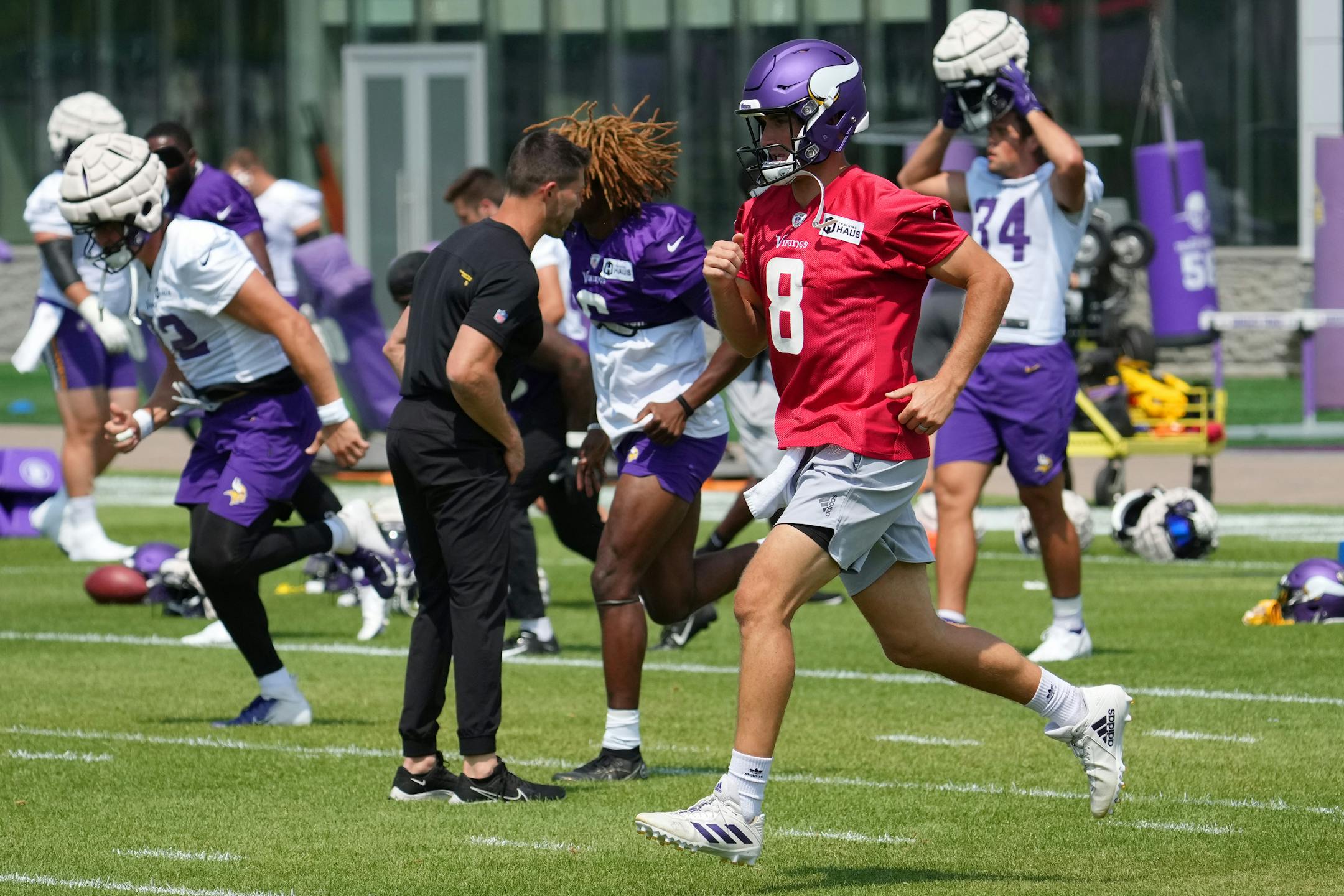 Minnesota Vikings quarterback Kirk Cousins (8) warms up with his teammates during training camp.