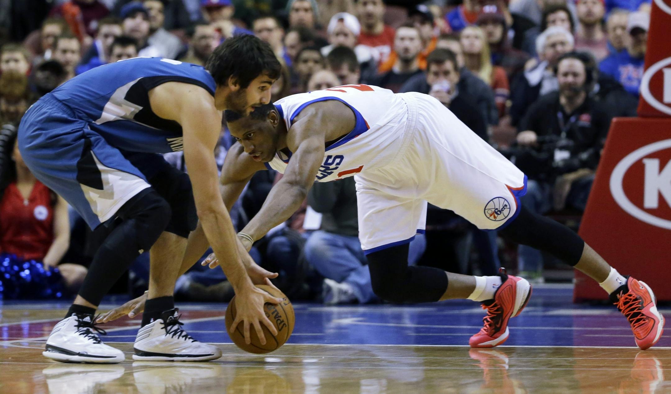 Philadelphia 76ers' Thaddeus Young, right, and Minnesota Timberwolves' Ricky Rubio, of Spain, chase down a loose ball during the first half of an NBA basketball game, Monday, Jan. 6, 2014, in Philadelphia.