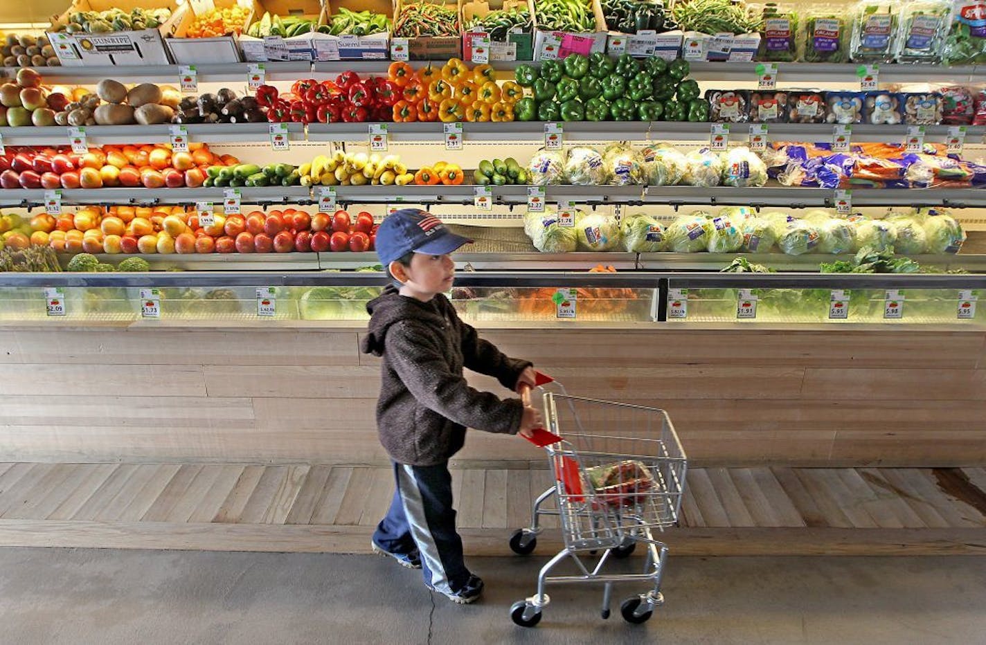 Jose Chavez, 3, followed his mother Clara Osorio down the fruit and vegetable aisles at the Good Grocer grocery store, Monday, September 5, 2015 in Minneapolis, MN.