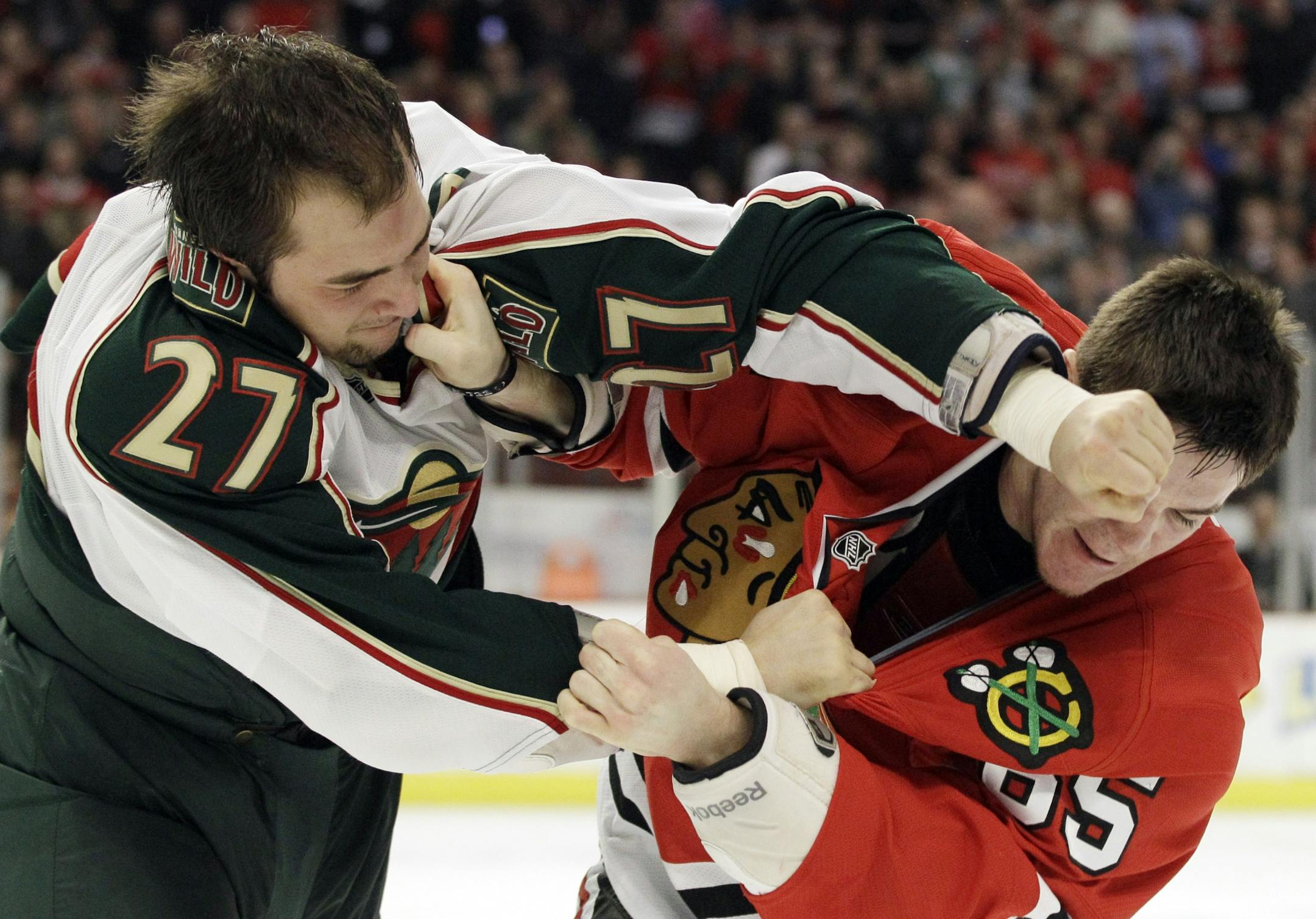 CORRECTS WILD PLAYER NAME TO CODY, NOT COREY - Minnesota Wild's Cody Almond (27) fights with Chicago Blackhawks' Andrew Shaw (65) during the second period of an NHL hockey game in Chicago, Sunday, April 1, 2012.