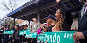 Council Member Anika Bowie and former Council Member Russel Balenger, far right, hold up “Rondo Ave” signs as part of a ceremony renaming the fron