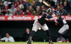 Minnesota Twins' Carlos Santana dodges an errant pitch during the eighth inning of the team's baseball game against the Los Angeles Angels, Friday, Ap