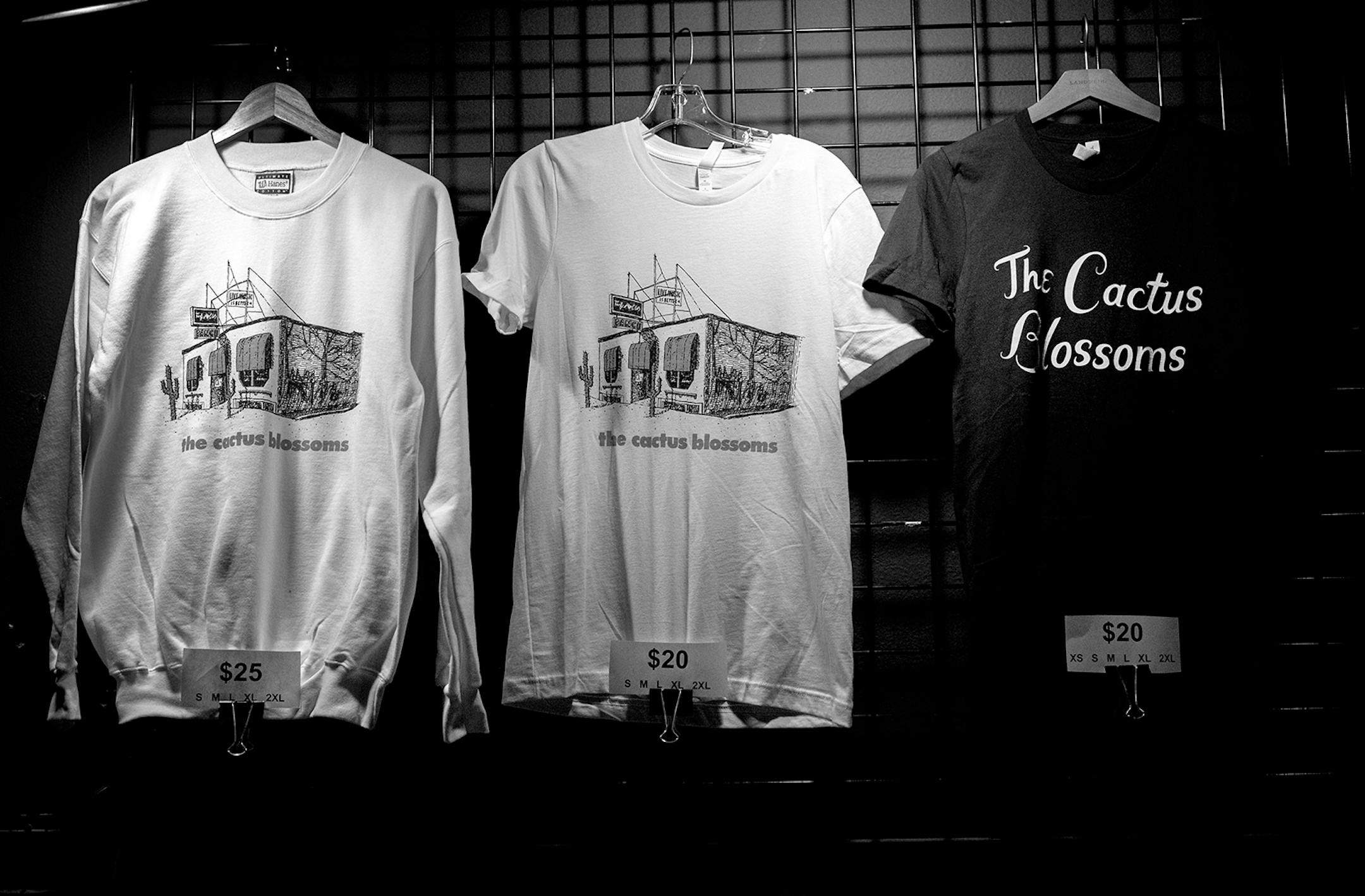 Merchandise of the Cactus Blossoms with a photo of the exterior of the Turf Club.