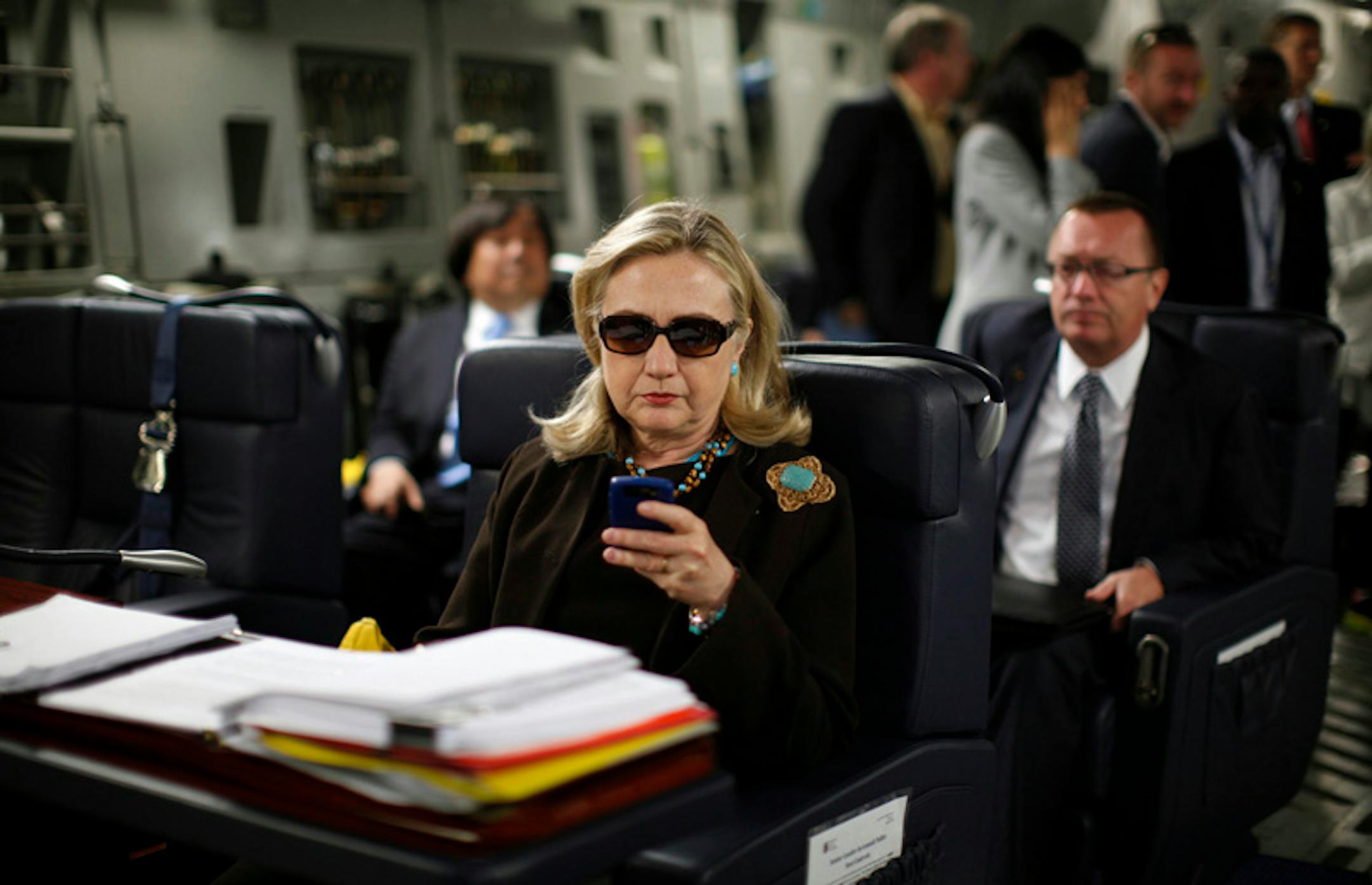U.S. Secretary of State Hillary Rodham Clinton works from a desk inside a C-17 military plane.