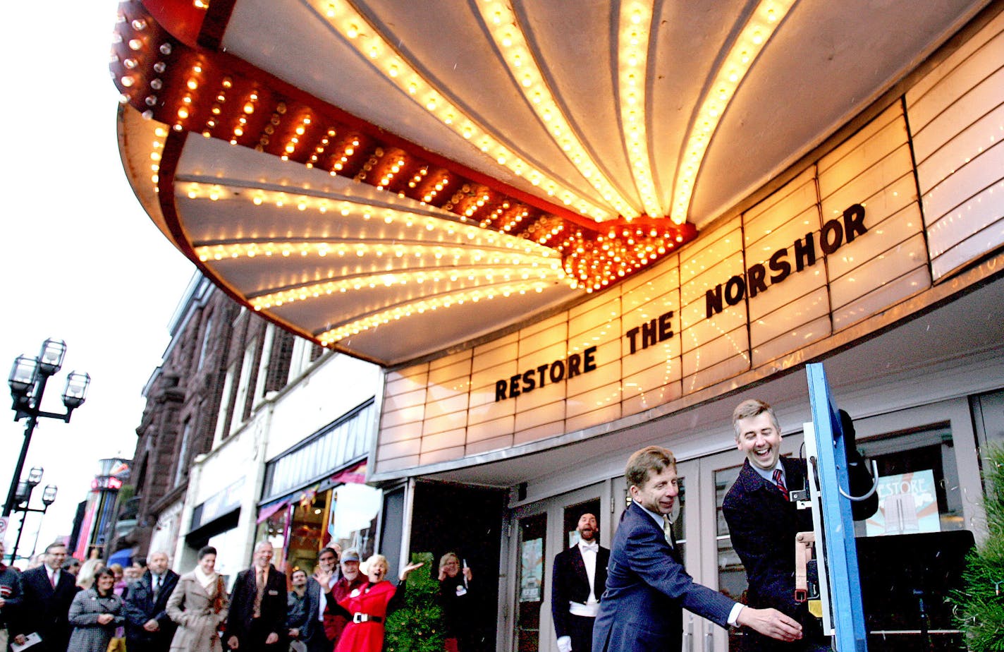 t10.29.2013 -- Steve Kuchera -- kucheraNORSHORE1030 -- Duluth Mayor Don Ness laughs after the NorShor Theatre&#x201a;&#xc4;&#xf4;s marquee lights come on before he and developer George Sherman flipped the switch that was to signal the marquee&#x201a;&#xc4;&#xf4;s lighting Tuesday. The lighting was part of an event celebrated the planned restoration of the building. Steve Kuchera / skuchera@duluthnews.com