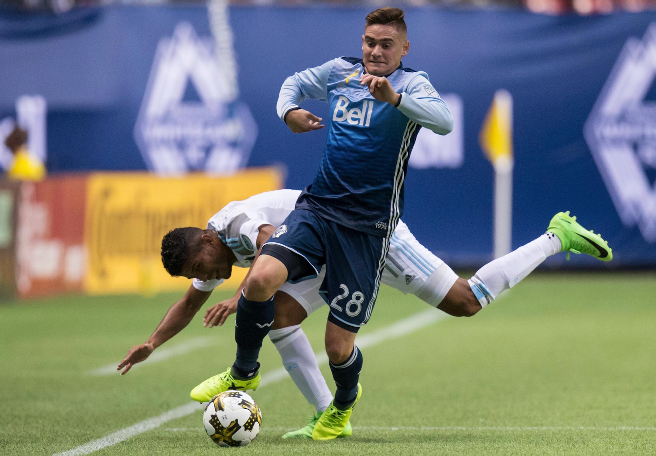Vancouver Whitecaps' Jake Nerwinski, front, takes control of the ball as Minnesota United's Johan Venegas stumbles during the first half of an MLS soccer match Wednesday, Sept. 13, 2017, in Vancouver, British Columbia. (Darryl Dyck/The Canadian Press via AP)