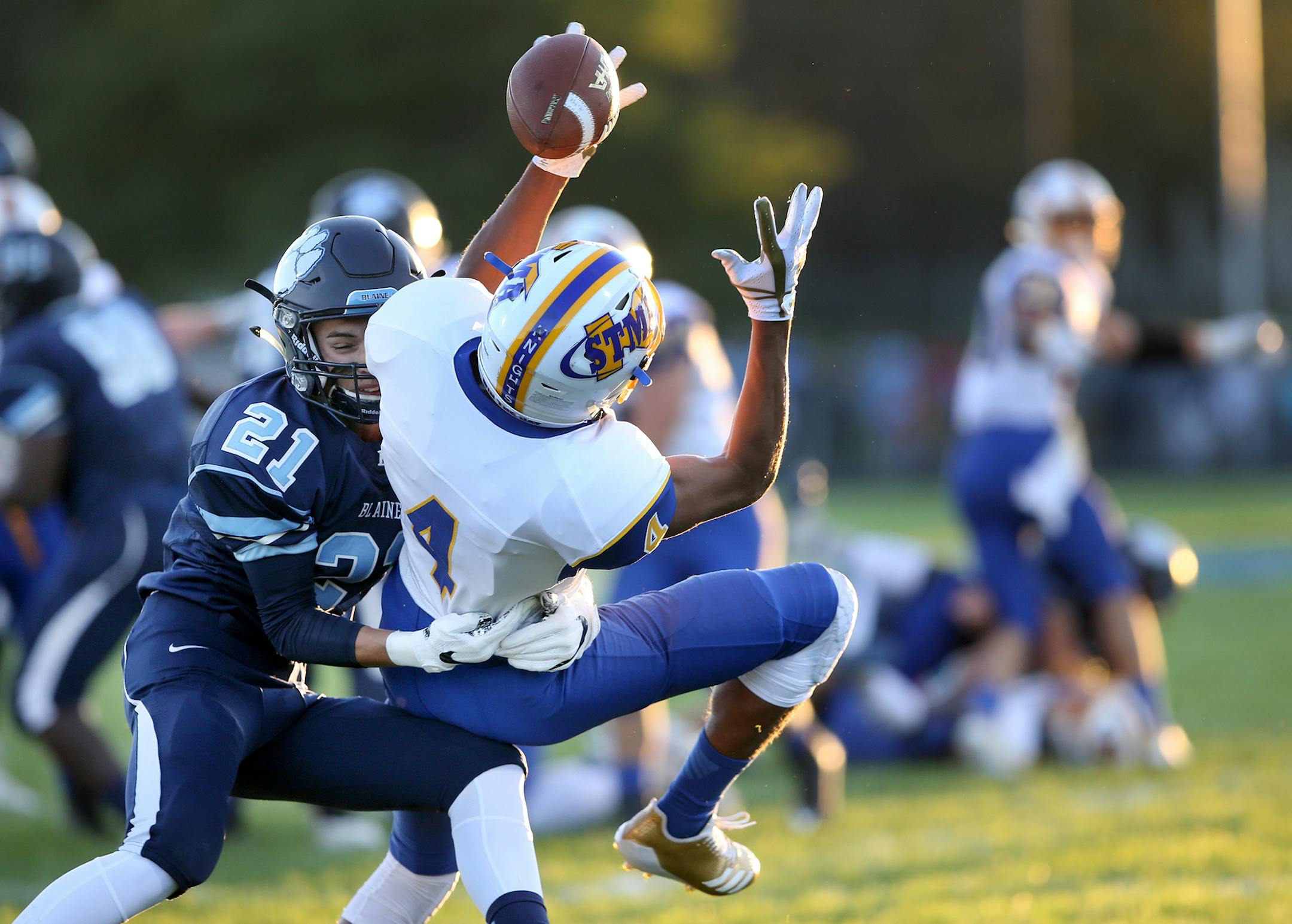 St. Michael-Albertville's Xavier Thurman (4) makes a circus catch near the two yard-line while being tightly covered by Blaine defensive back Mikey Gottschalk (21) during the first quarter Friday, Sept. 8, 2017, at Blaine High in Blaine, MN.] DAVID JOLES ï david.joles@startribune.com Prep football