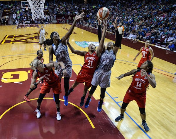 Minnesota Lynx and Washington Mystics players, including Minnesota's Sylvia Fowles (34) and Maya Moore (23), battled for a first half rebound with Was