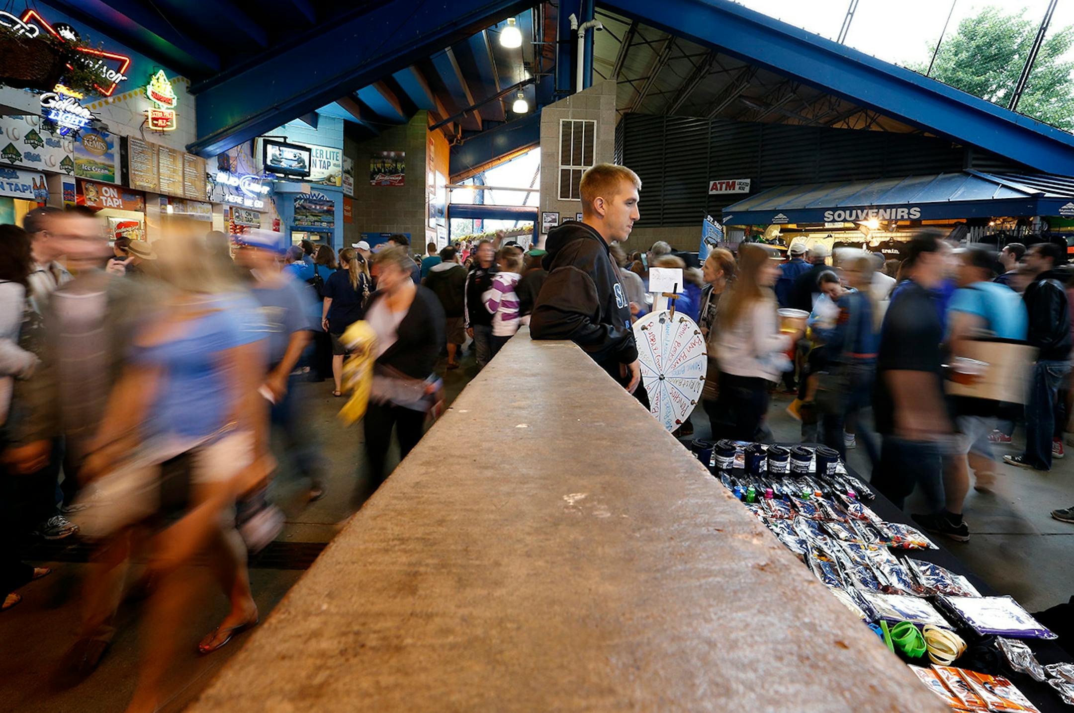 Fans walked to their seats as St. Paul Saints intern Dan Brown, 24, (middle) of Maple Grove sold memorabilia before the St. Paul Saints final game at Midway Stadium on Thursday night. ] CARLOS GONZALEZ cgonzalez@startribune.com - August 28, 2014, St. Paul, Minn., Midway Stadium, St. Paul Saints baseball vs. Winnipeg - Final Saints game at Midway Stadium