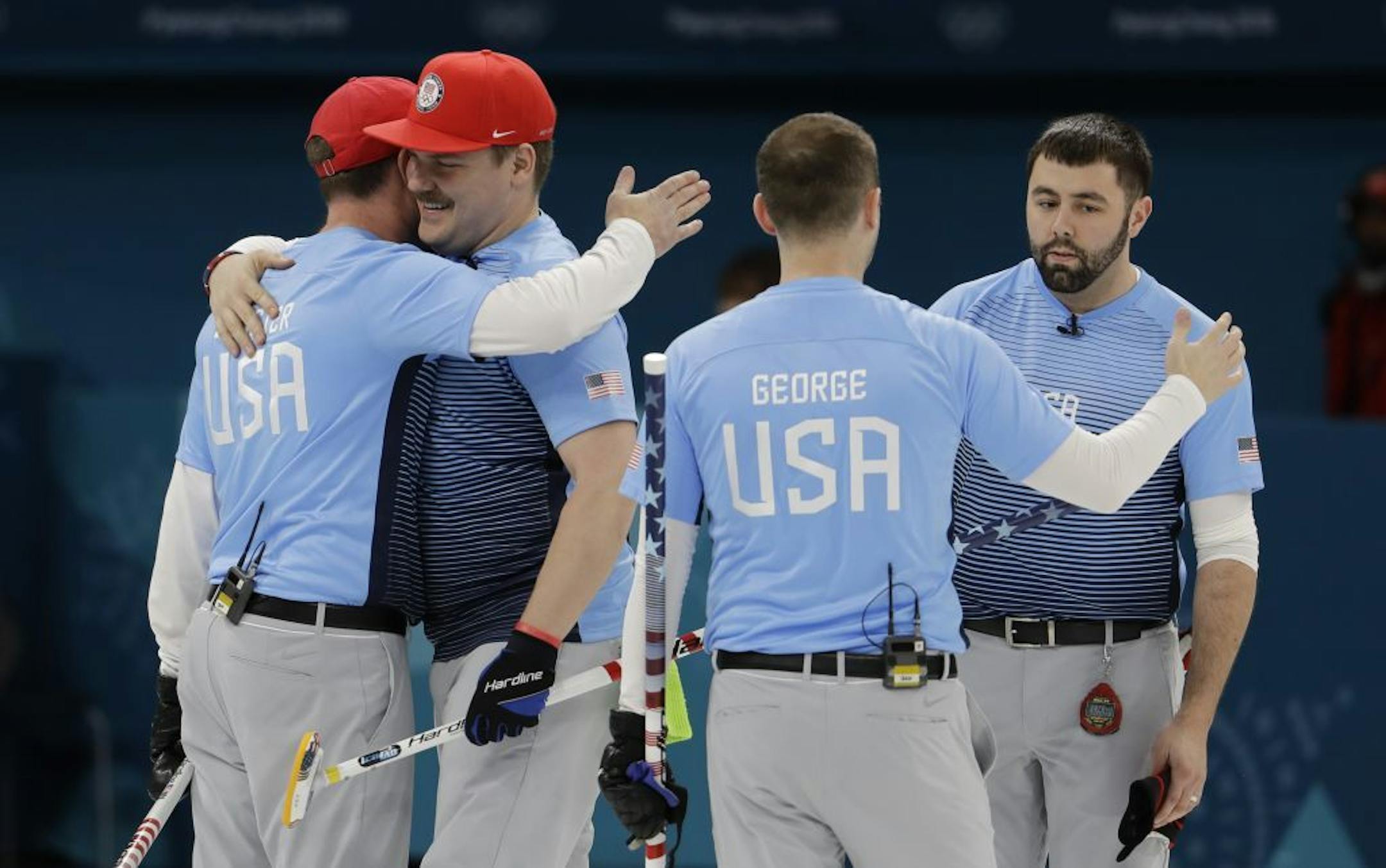 United States team members celebrate winning a men's curling match against Britain at the 2018 Winter Olympics in Gangneung, South Korea, Wednesday, Feb. 21, 2018.