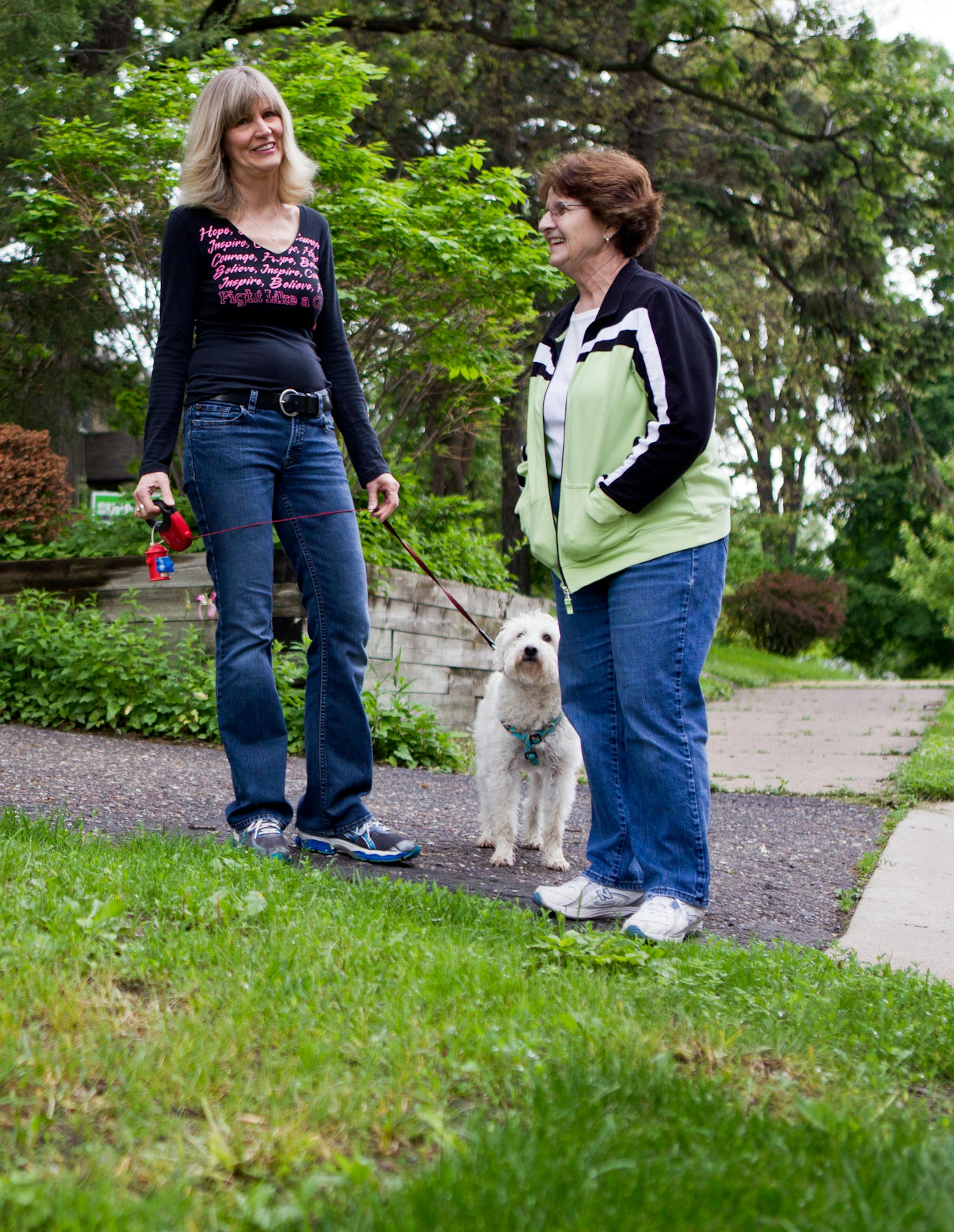 Neighbors Katherine McManus, left, with her dog Tanner, and Rita DeBrobander stand at the edge of the sidewalk on their street in St. Louis Park, Minn., on Thursday, June 6, 2013. Three houses on Zarthan St., including theirs, don't have sidewalks in front of their homes. They are scheduled to have sidewalks installed in 2016, but McManus and DeBrobander want the gap filled earlier for safety and social reasons in their neighborhood. ] (ANNA REED/STAR TRIBUNE) anna.reed@startribune.com (cq)