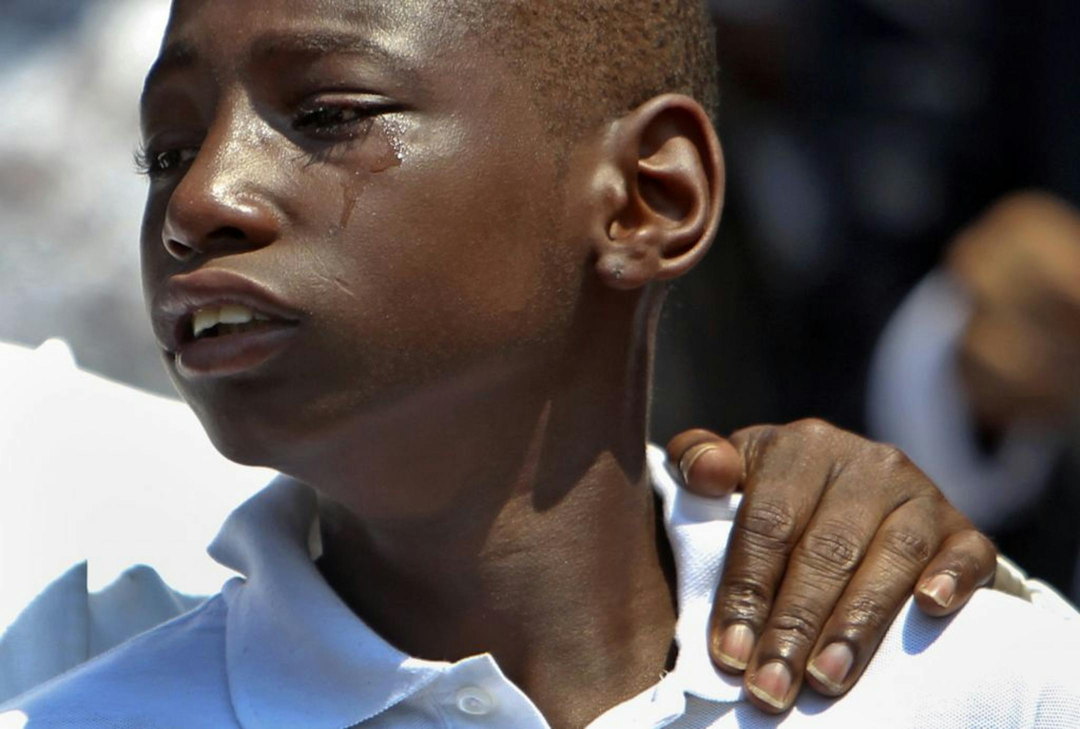 A young mourner was comforted outside the Shiloh Temple in Minneapolis. Several hundred people attended the service for 5-year-old Nizzel George.