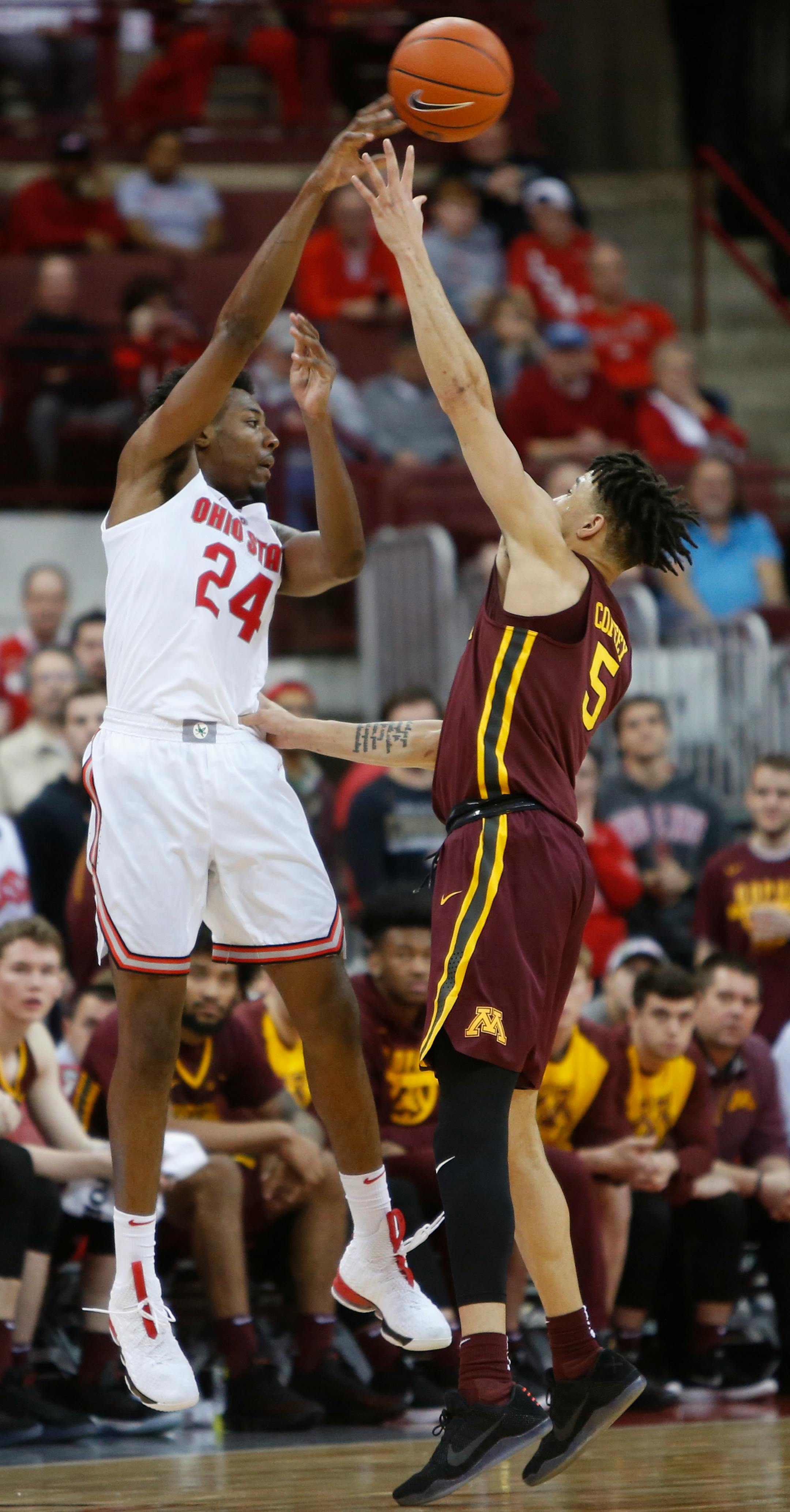 Ohio State's Andre Wesson, left, passes the ball over Minnesota's Amir Coffey during the second half of an NCAA college basketball game Sunday, Dec. 2, 2018, in Columbus, Ohio. Ohio State beat Minnesota 79-59. (AP Photo/Jay LaPrete)