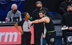 Minnesota Timberwolves guard Ricky Rubio, right, argues with referee Danielle Scott as Timberwolves coach Chris Finch looks on during the second half 