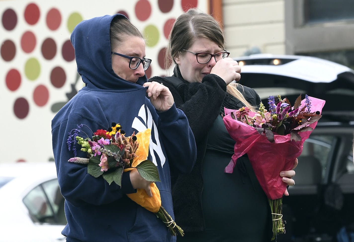 People place flowers, Sunday, Oct. 7, 2018, at the scene where 20 people died as the result of a limousine crashing into a parked and unoccupied SUV at an intersection a day earlier, in Schoharie, N.Y. (AP Photo/Hans Pennink)