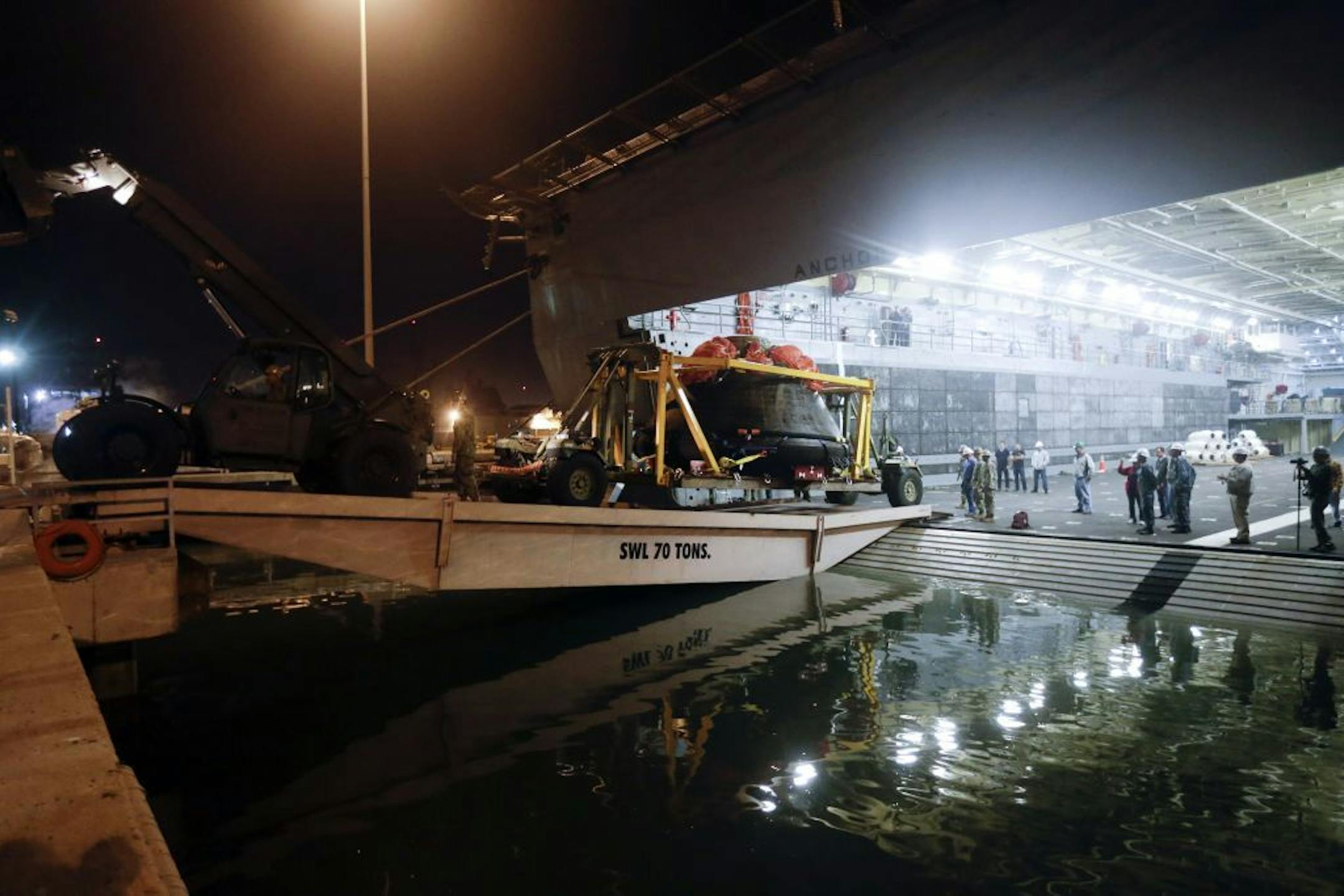 NASA's Orion space capsule to the dock, up a ramp from the USS Anchorage at Naval Base San Diego Monday, Dec. 8, 2014, in San Diego.