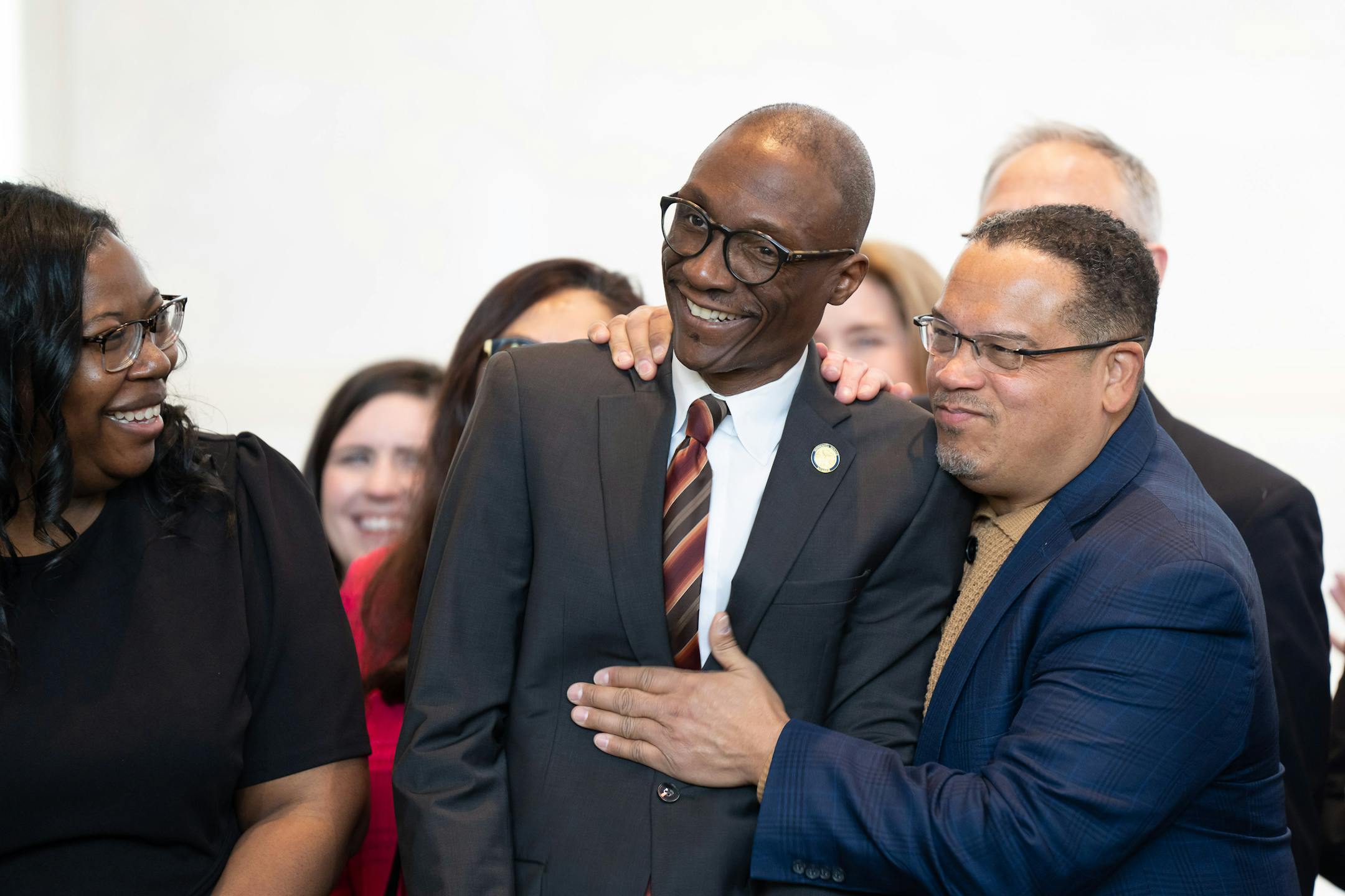 State Attorney General Keith Ellison patted Senate President Bobby Joe Champion, DFL-Minneapolis after Walz congratulated him on presiding over the Senate for all 14 hours of debate on the bill. On the left is Planned Parenthood CEO Ruth Richardson.