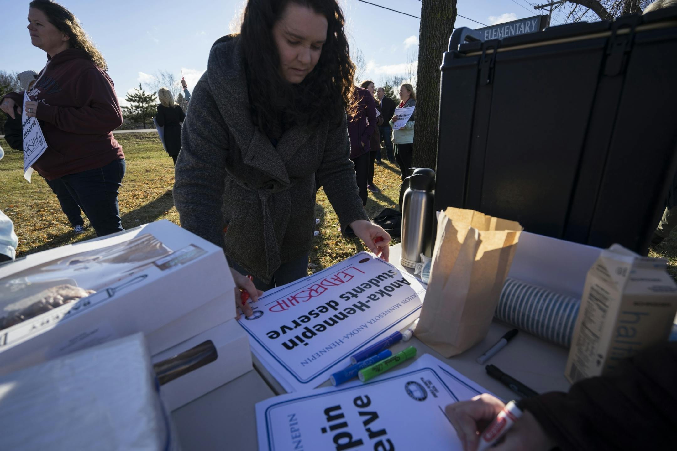 Supporter Sarah Lenloue fills out a sign during a walk in on Thursday, April 18, 2018 outside of Ramsey Elementary School in Ramsey, Minn.